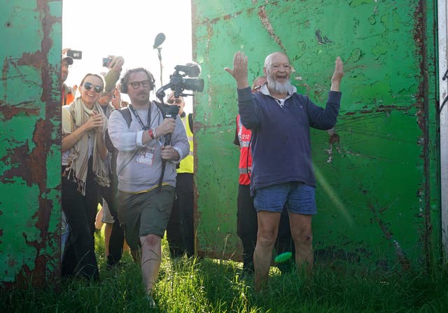<p>Michael Eavis and his daughter Emily Eavis open the gates on the first day of Glastonbury Festival at Worthy Farm in Somerset (Yui Mok/PA)</p>