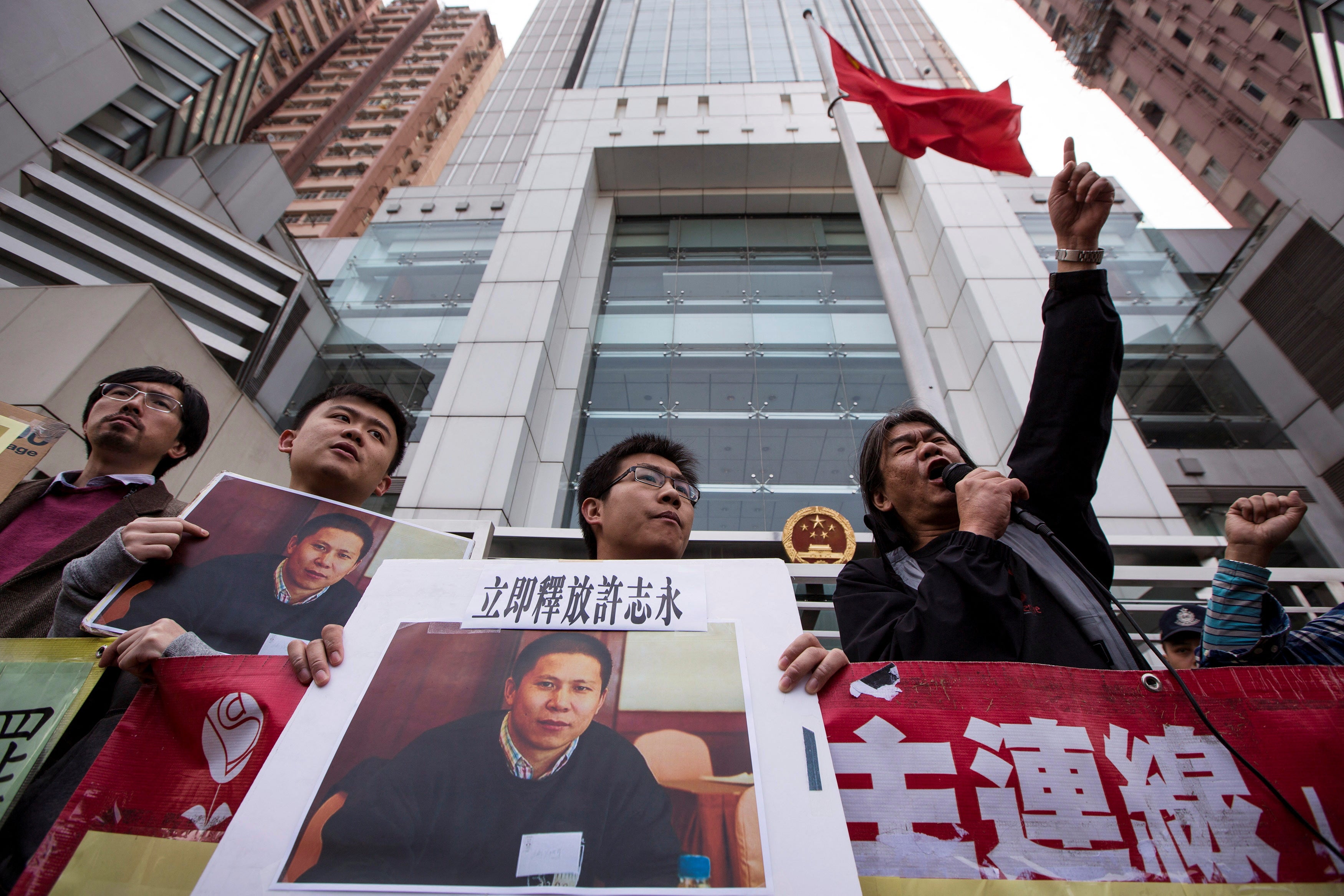 <p>Protesters hold images of Chinese rights advocate Xu Zhiyong</p>