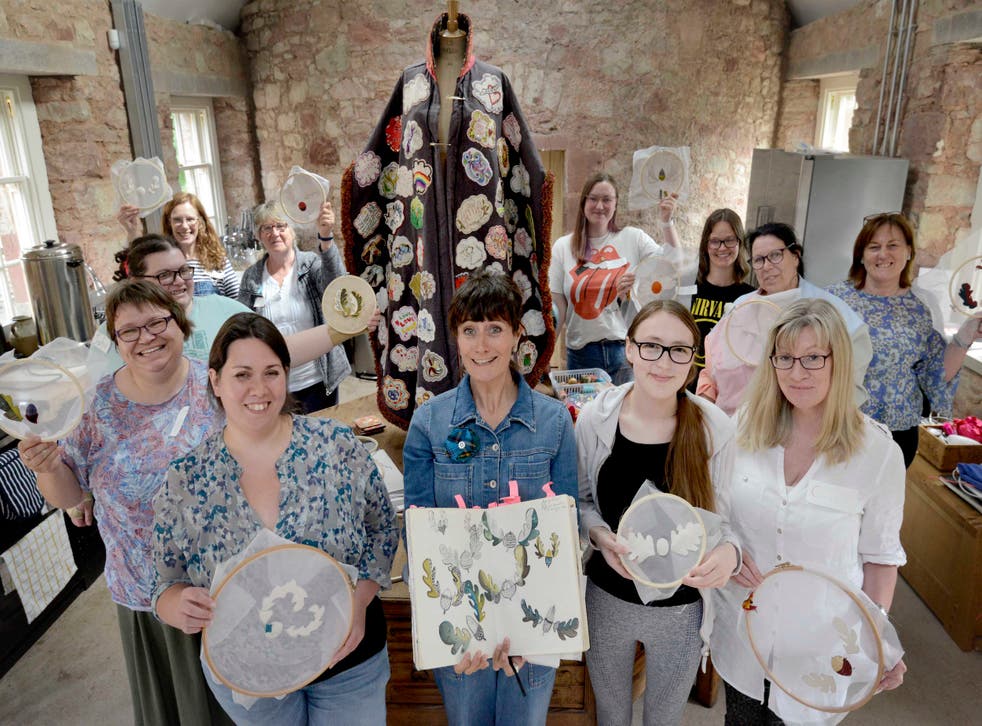 Louise Gardiner with people stitching flying acorn designs for the project (Colin Hattersley Photography/PA)