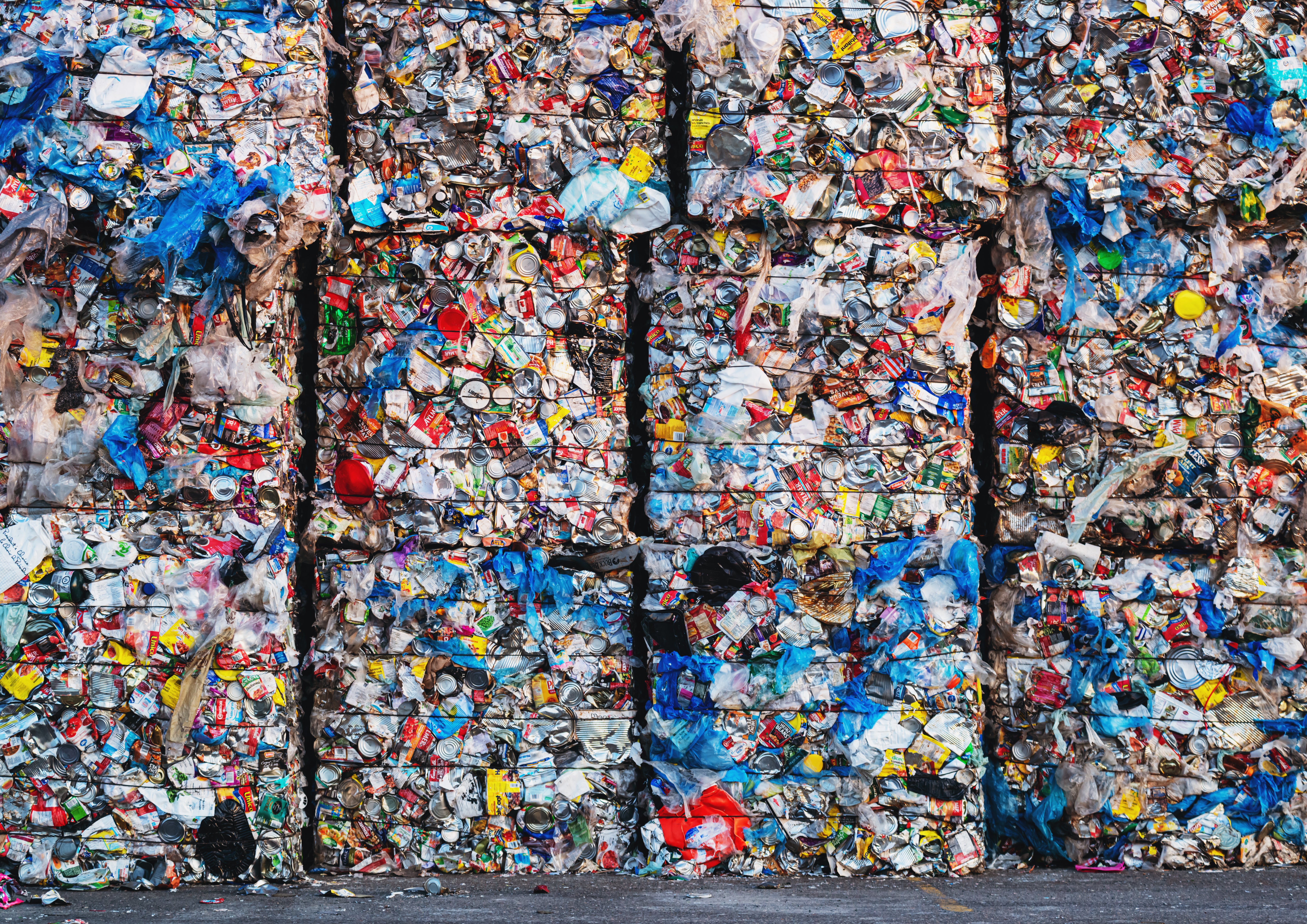 Large bundles of plastic bags, cans and milk containers await processing at a recycling center in Canada.