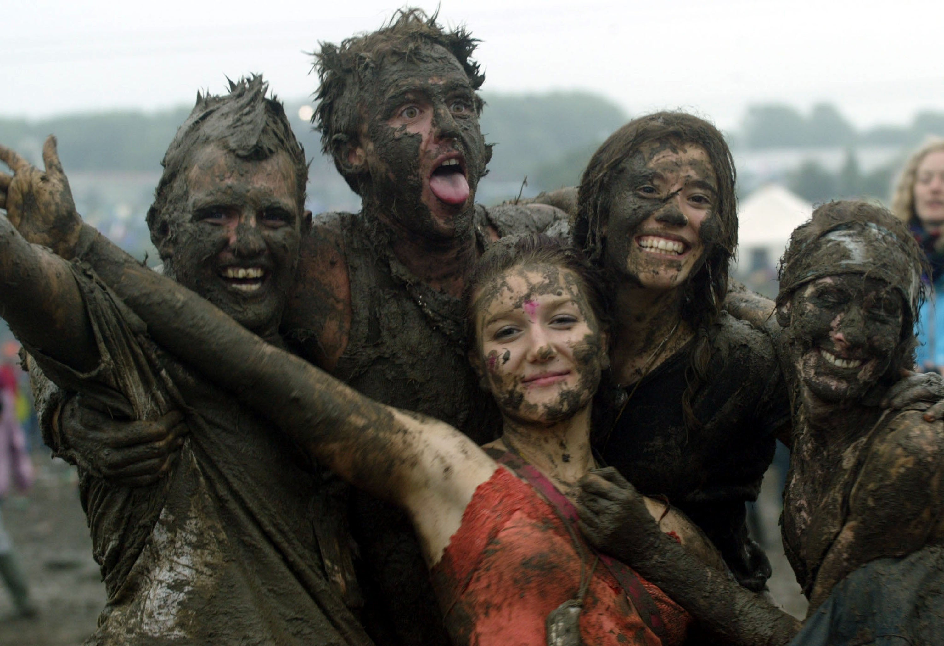 Festival-goers dance in the mud in front of the Pyramid stage in 2004