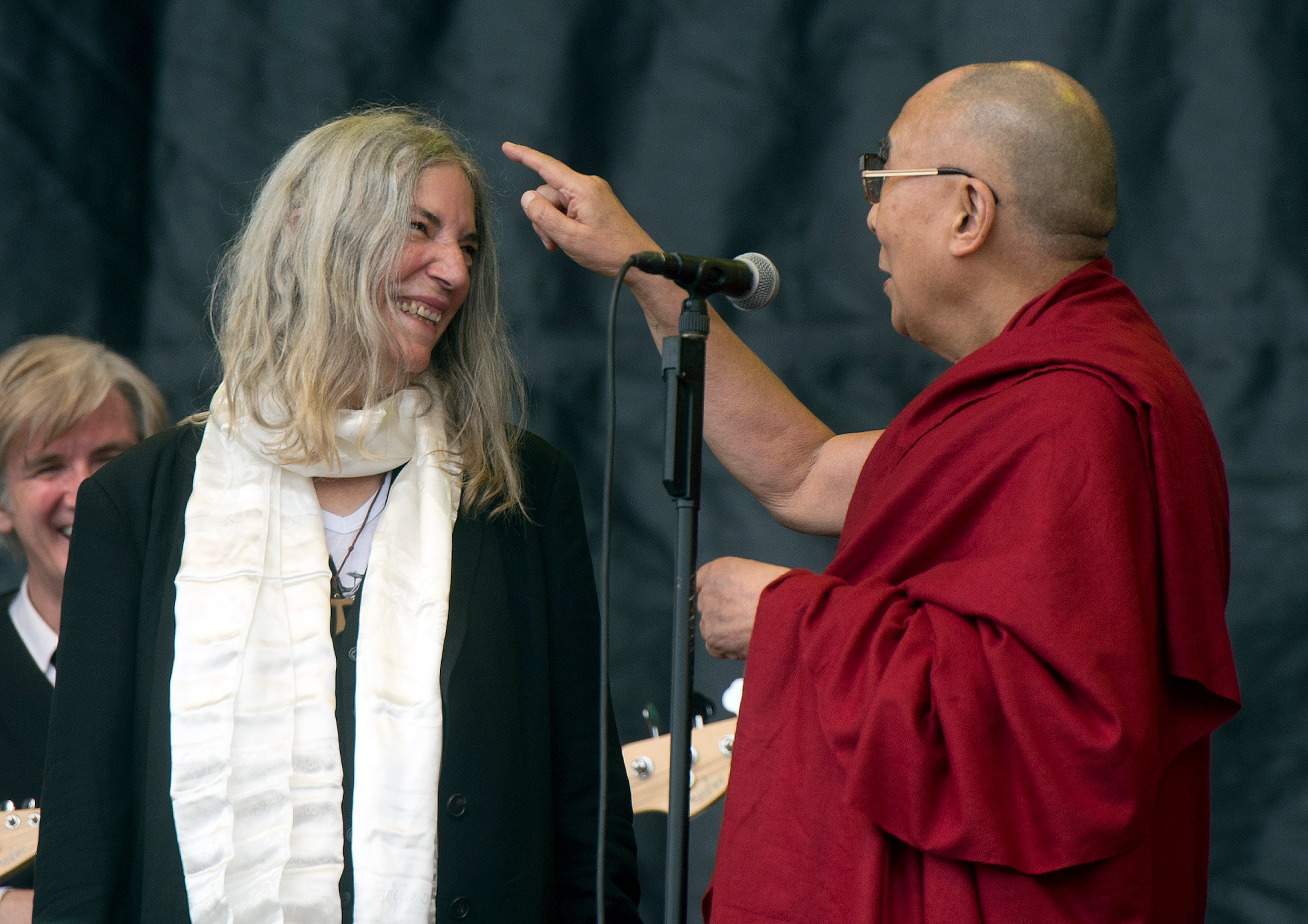 Tibetan spiritual leader, the Dalai Lama (R) joins US singer-songwriter Patti Smith (L) on The Pyramid Stage in 2015