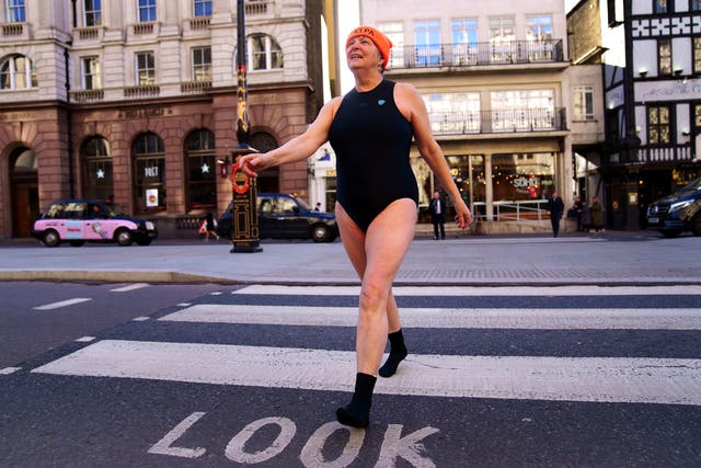 A swimmer from Hampstead Ponds crosses the road outside the Royal Courts of Justice, London (Victoria Jones/PA)