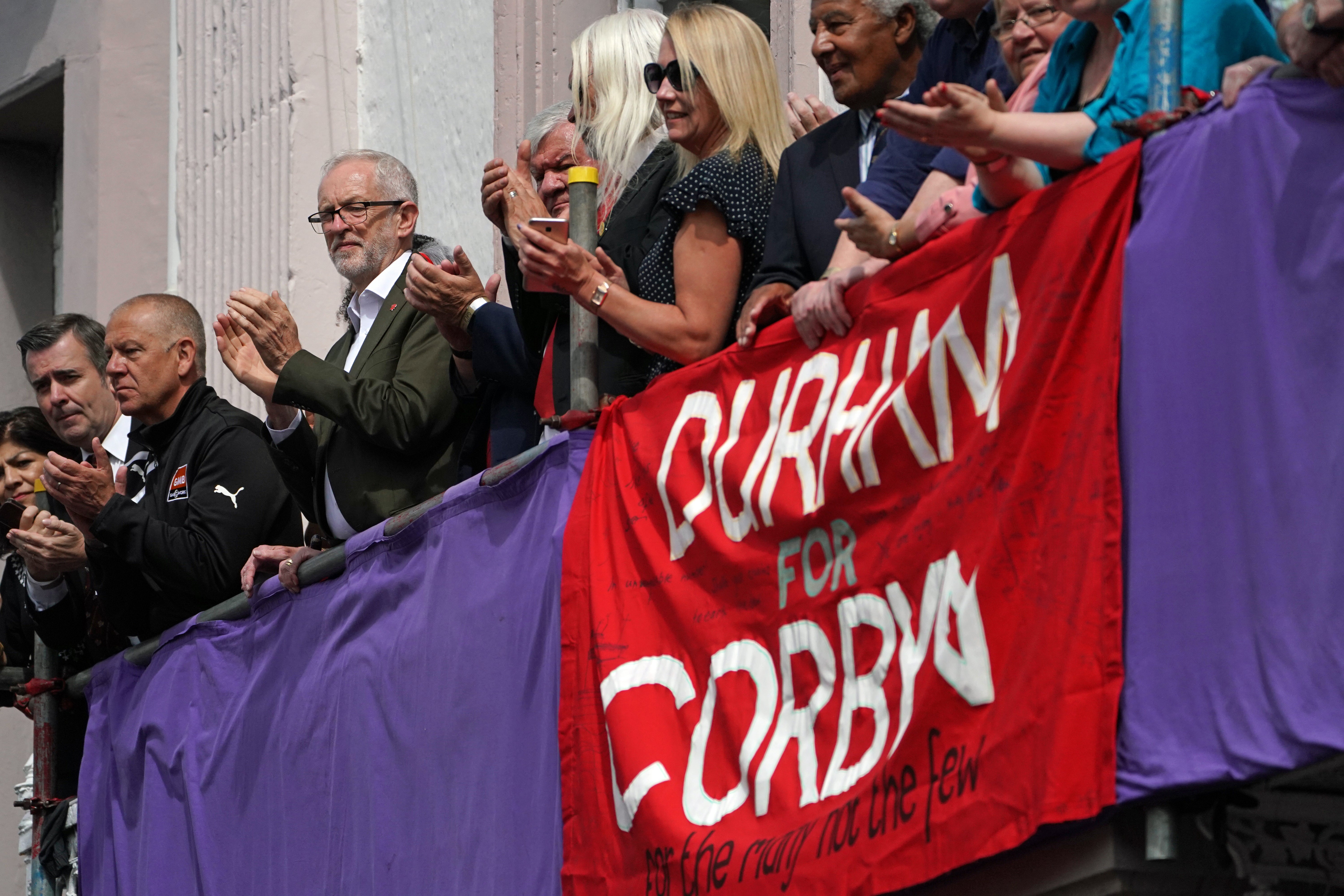 Labour leader Jeremy Corbyn watches the procession from the hotel balcony (PA)