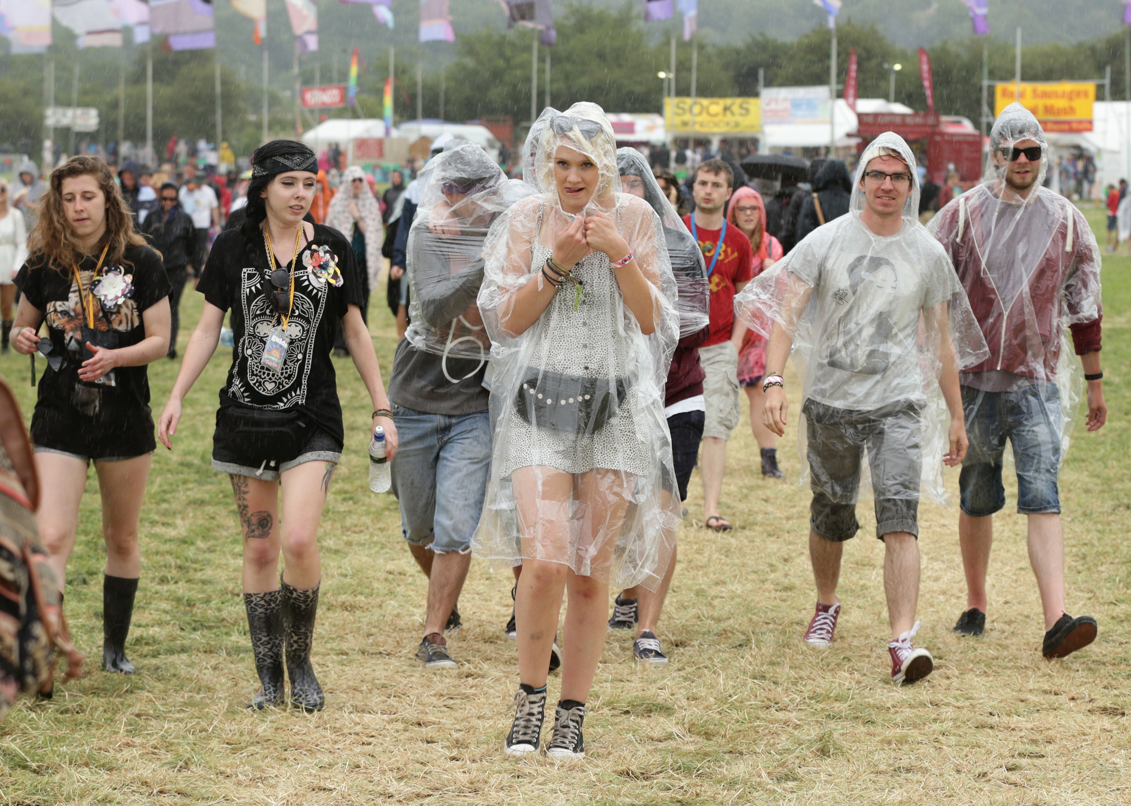 Festival goers during a rain shower at the Glastonbury Festival (PA)