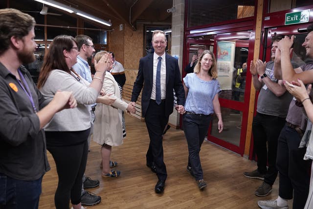 Liberal Democrat candidate Richard Foord and his wife Kate are greeted by supporters as they arrive at the count for the Tiverton & Honiton by-election in Crediton, Devon (Andrew Matthews/PA)