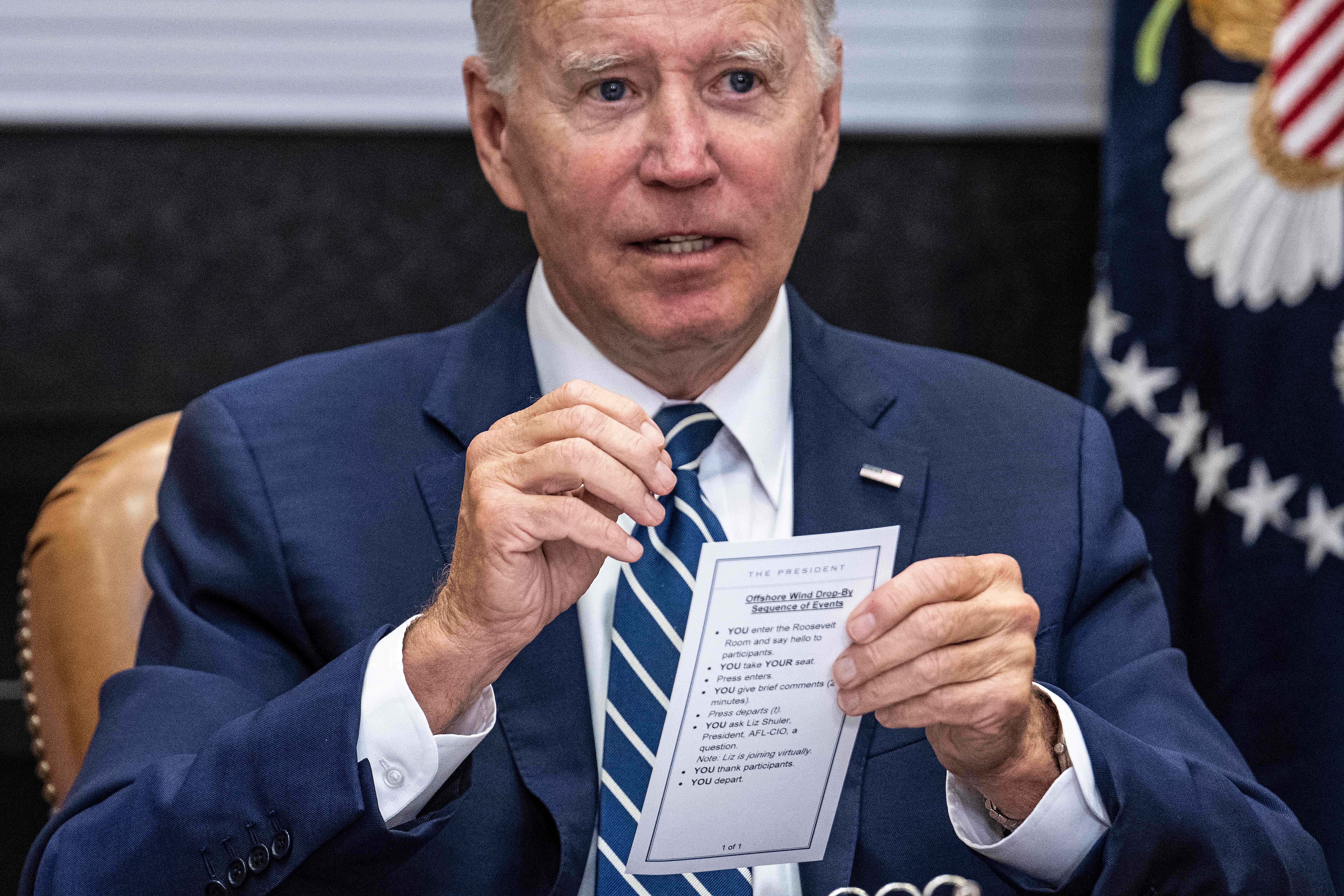 Joe Biden speaks from his notes with governors, labor leaders and private companies launching the Federal-State Offshore Wind Implementation Partnership as he drops by a meeting at the White House in Washington, DC on 23 June