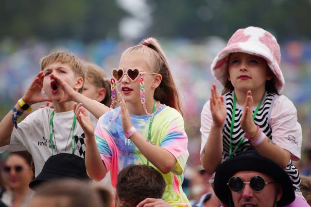 Young fans are lifted on the shoulders of mums and dads to enjoy Ziggy Marley performing on the Pyramid Stage at Glastonbury (Ben Birchall/PA)