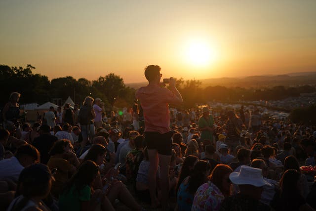 Festivalgoers watch the sunset (PA)