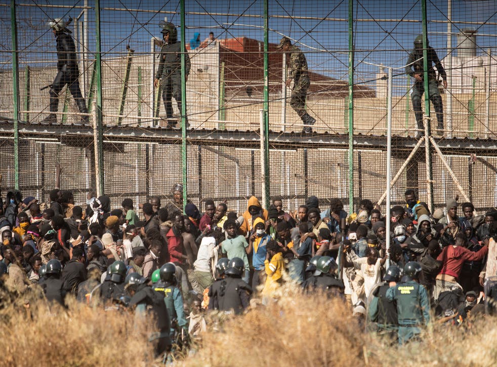 <p>Migrants climb the fences separating the Spanish enclave of Melilla from Morocco in Melilla, Spain</p>