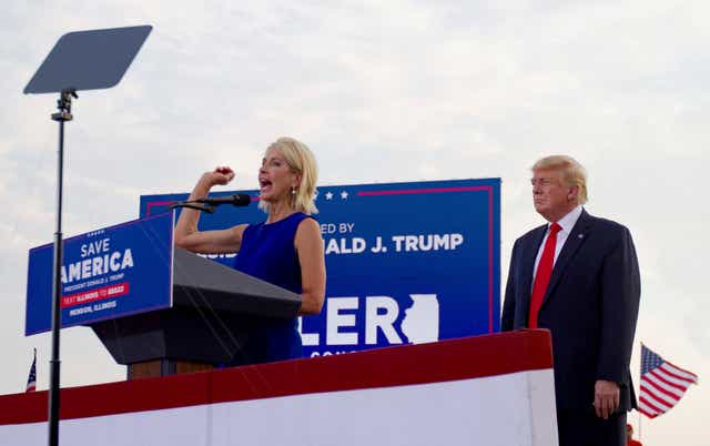 <p>Mary Miller, of Illinois, speaks as former president Donald Trump stands behind her on stage at the rally </p>