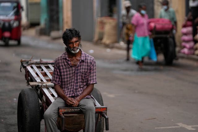 <p>A daily wage laborer waits for work at a wholesale market in Colombo, Sri Lanka on 26 June</p>