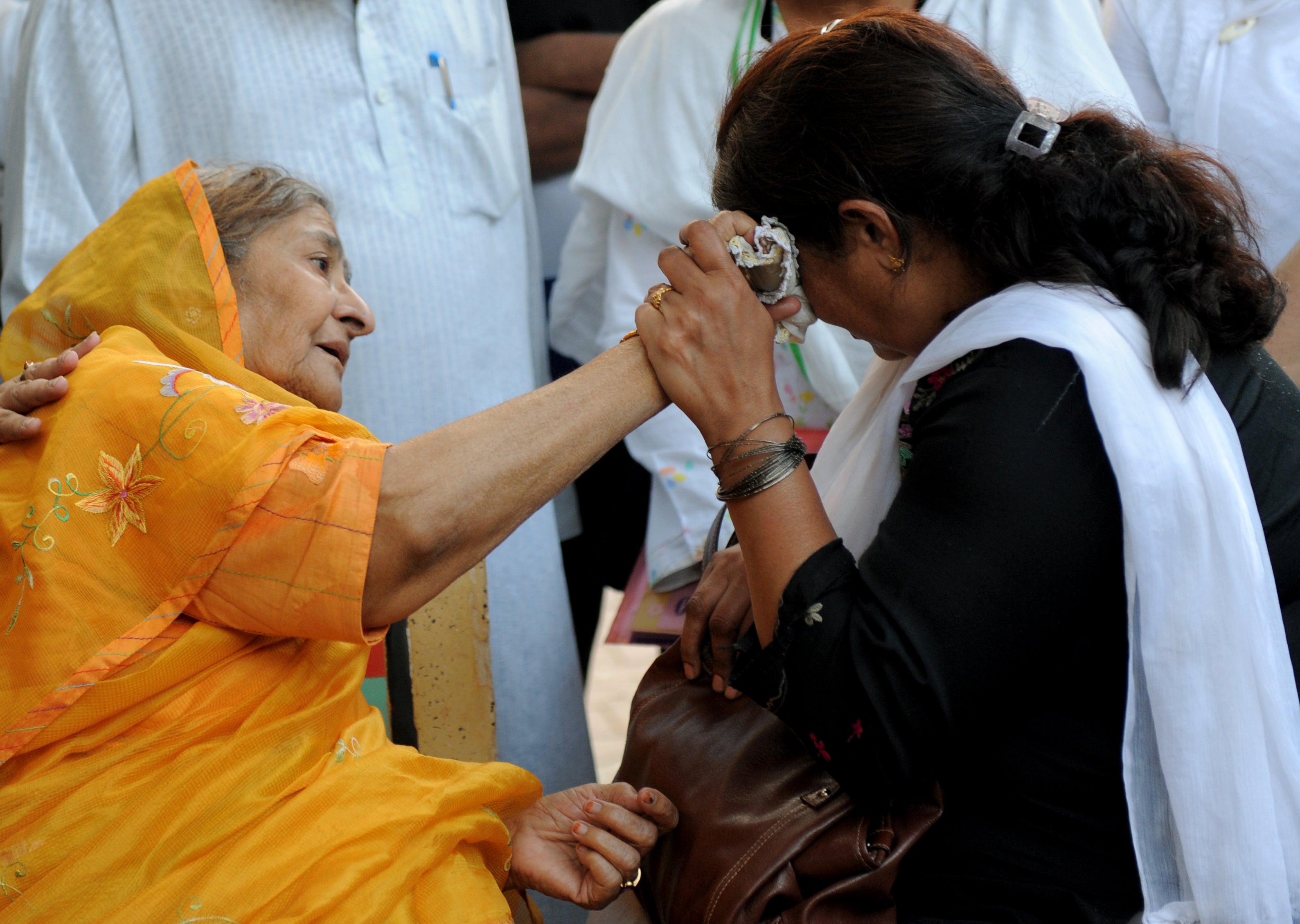 Widow Zakia Jafri (L) comforts grieving mother Rupa Modi outside a court in Ahmedabad on 26 December, 2013, following a judgement over the riots in favour of then-Gujarat chief minister Narendra Modi