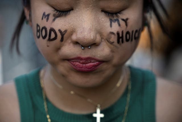 <p>A young woman protests outside of the Supreme Court after Roe vs Wade is overturned </p>