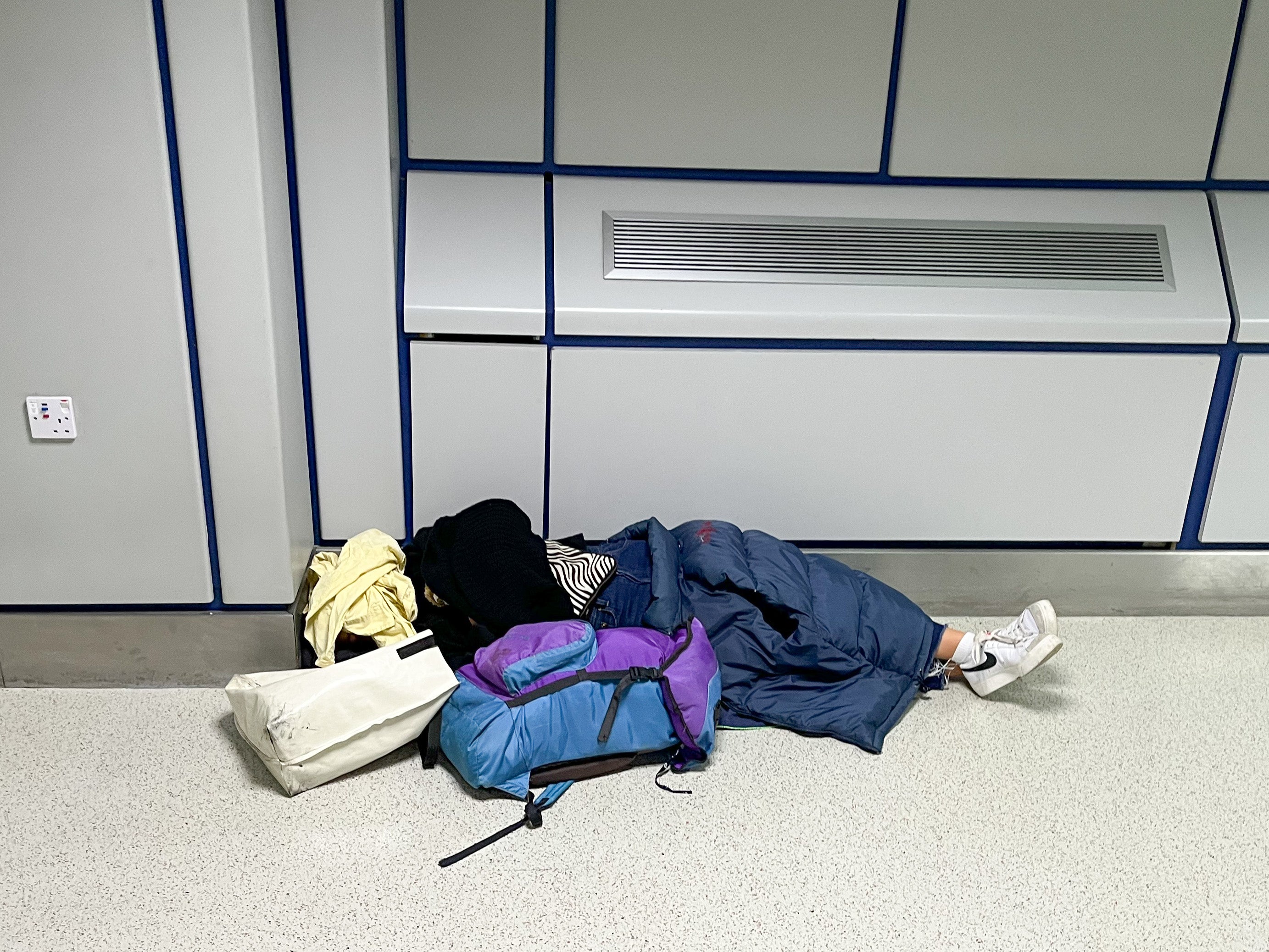 A passenger rests before her flight at Manchester Airport Terminal 3