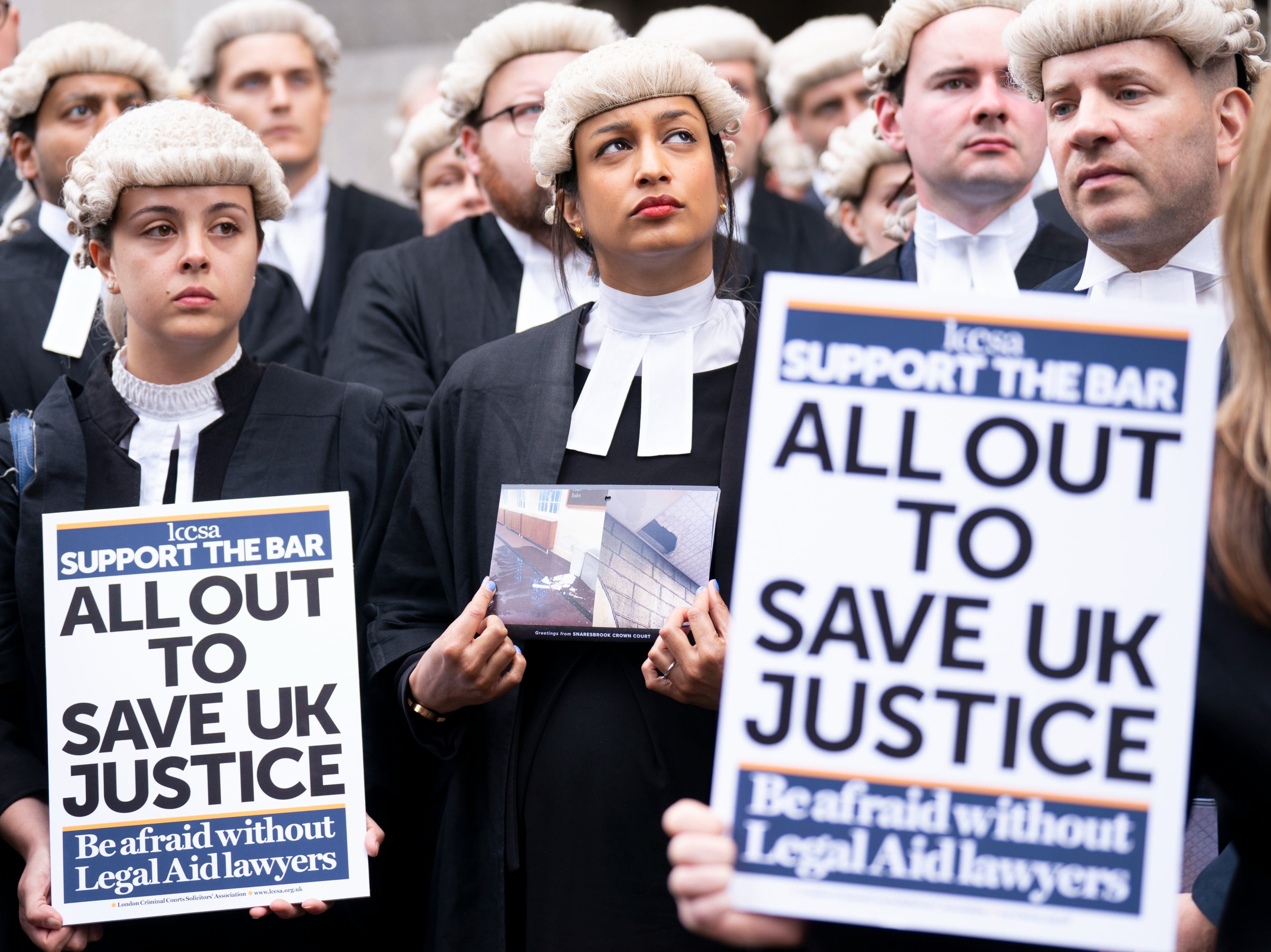 Criminal barristers from the Criminal Bar Association (CBA), which represents barristers in England and Wales, outside the Old Bailey, central London, on the first of several days of court walkouts by CBA members in a row over legal aid funding