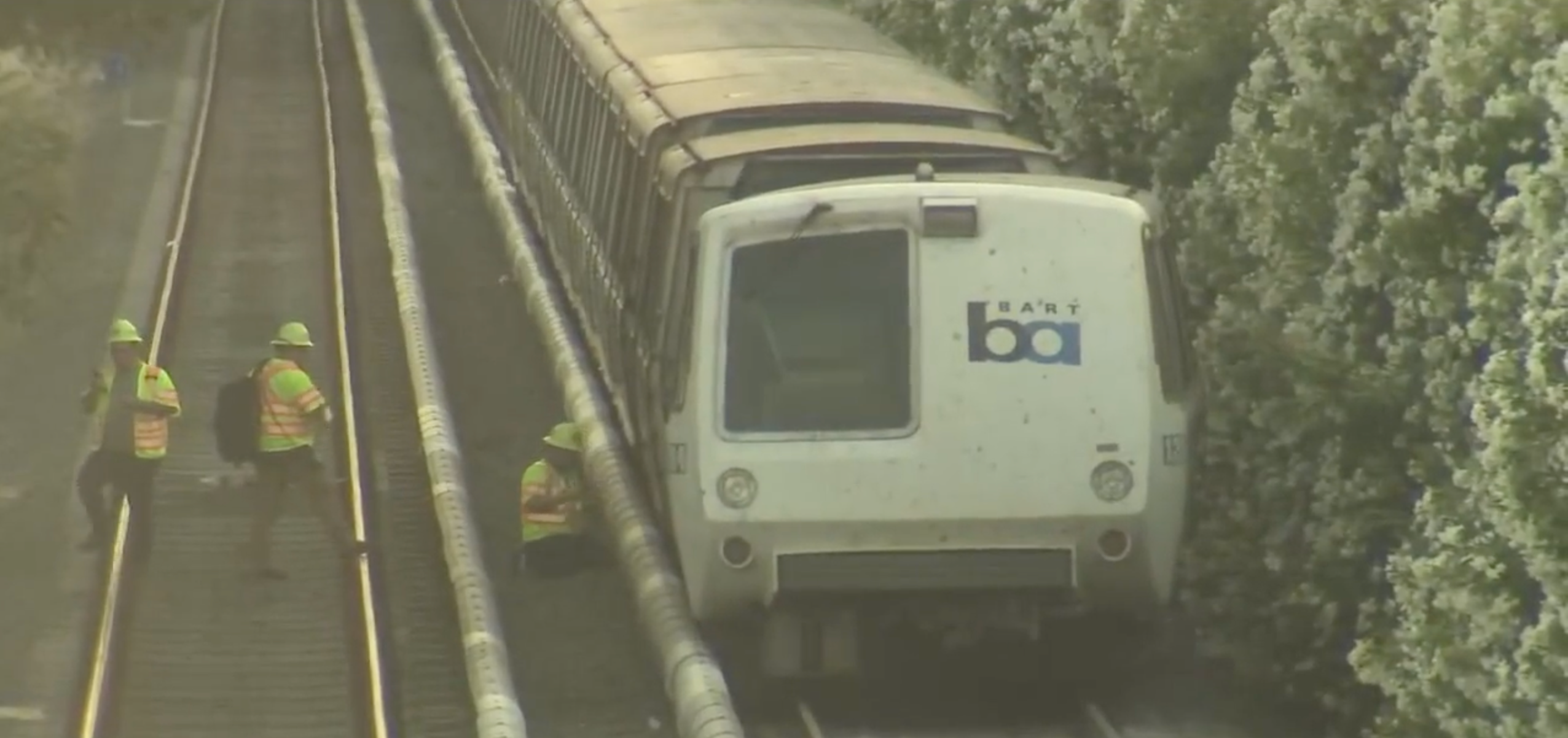<p>Workers next to a BART train that partially derailed last week </p>