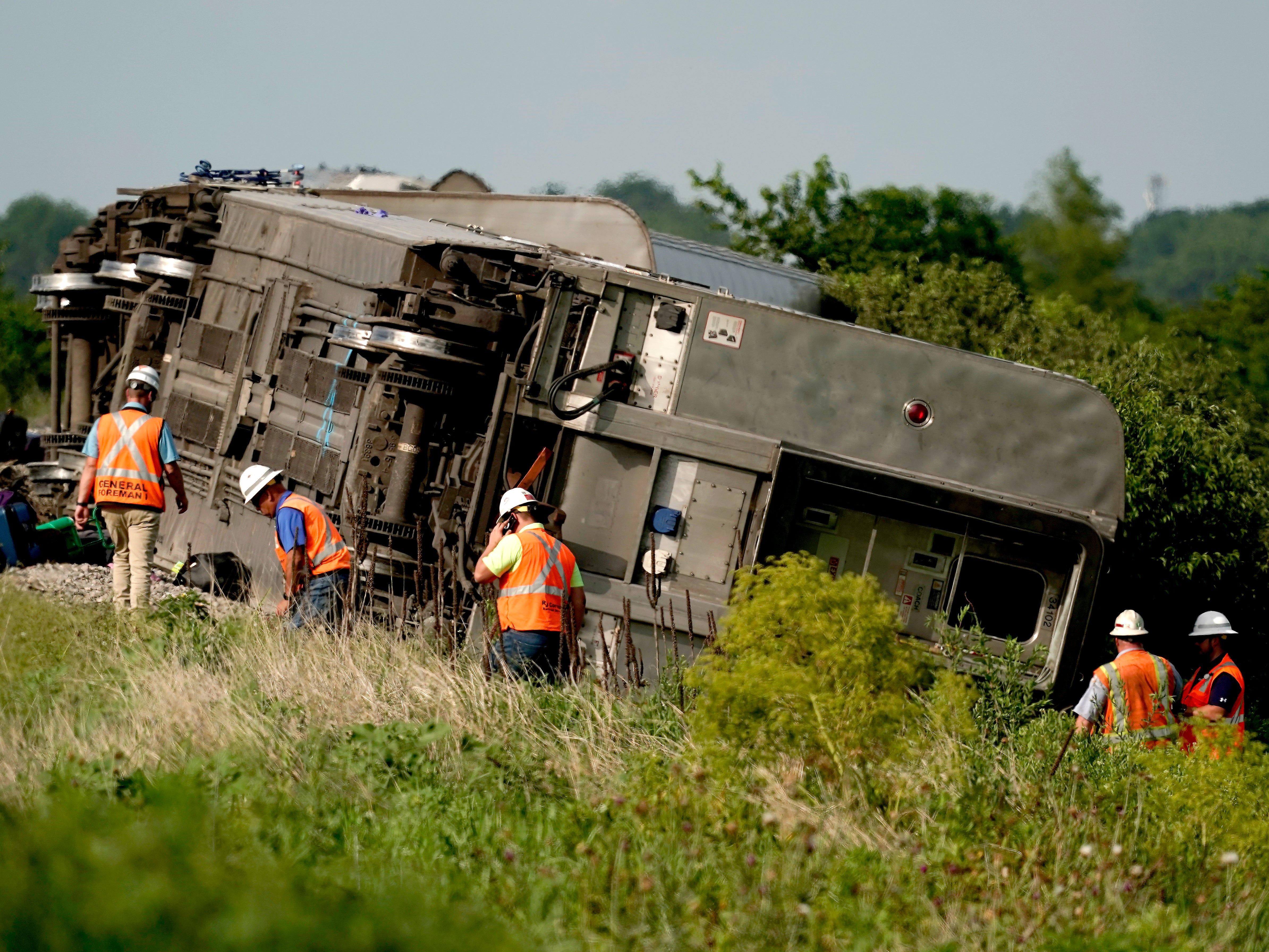 Workers inspect a derailed Amtrak train near Mendon, Missouri, on Monday 27 June 2022