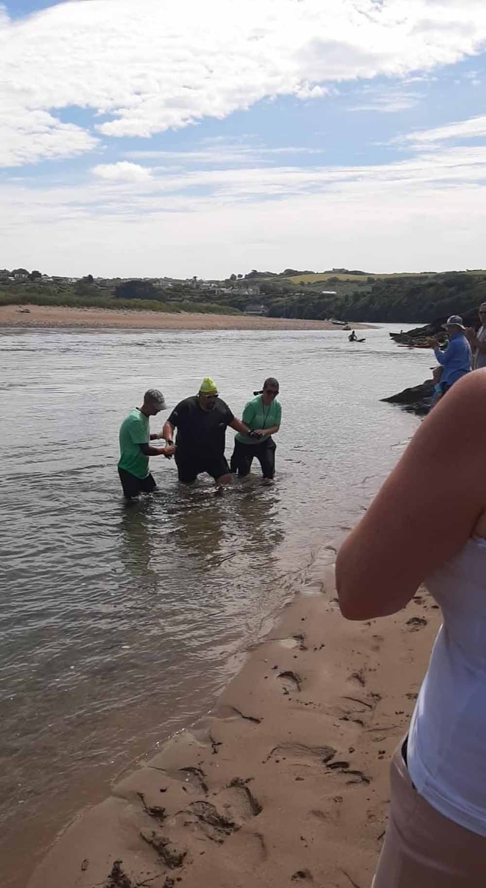 Stuart pictured here being helped out of the water after the swim event. (Collect/PA Real Life)