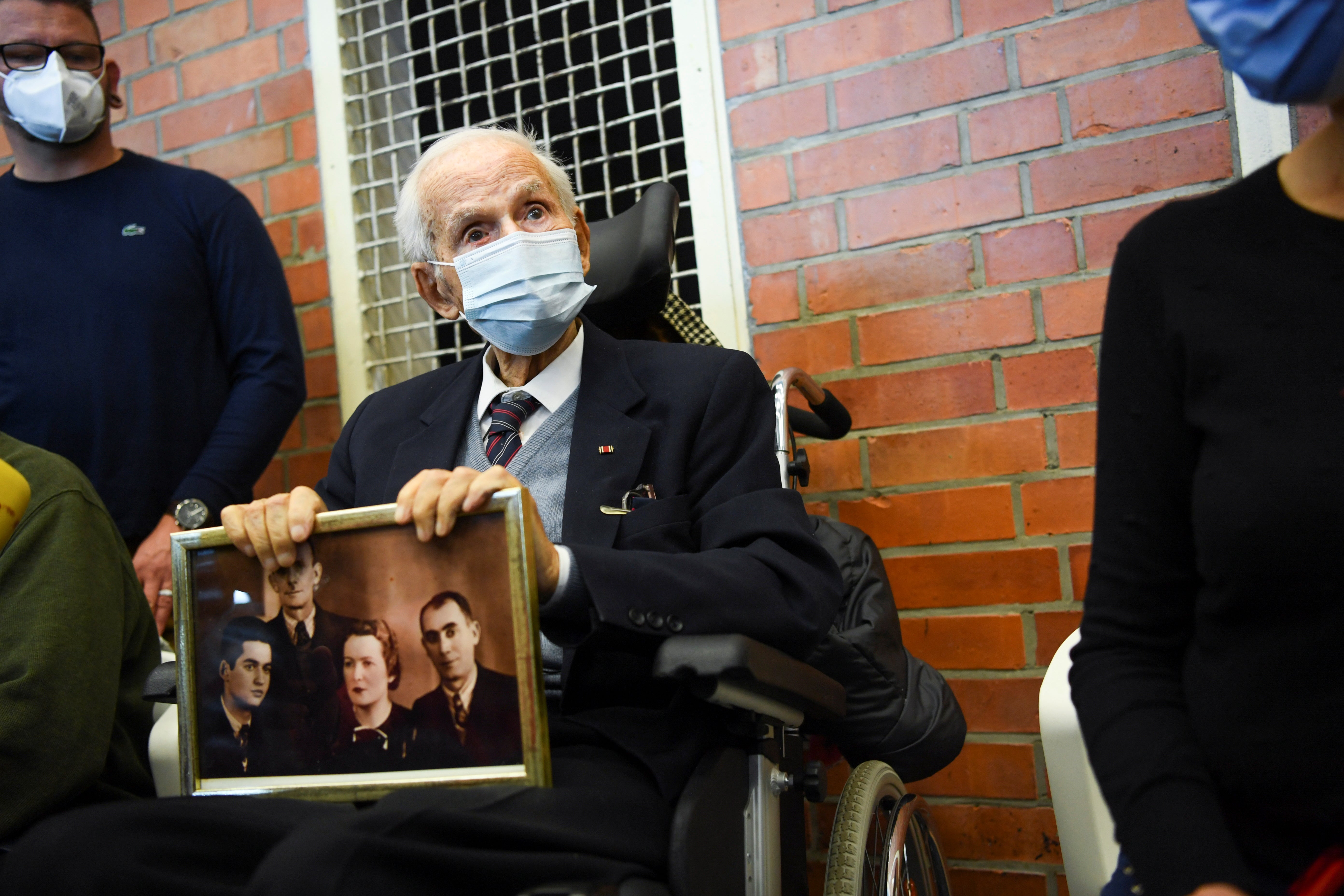 Holocaust survivor Leon Schwarzbaum holds a picture in the courtroom during the trial