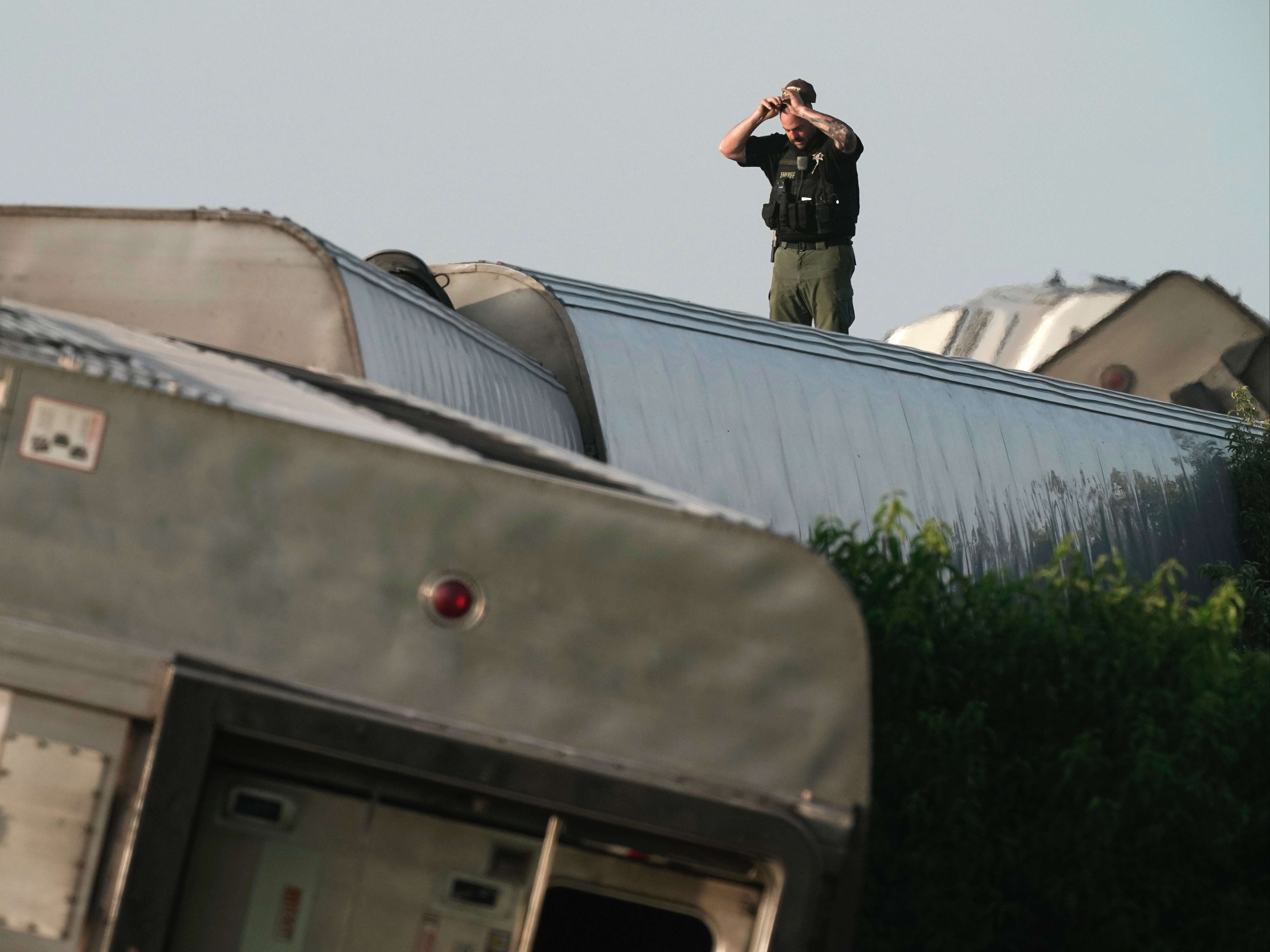 A law enforcement officer inspecting the scene of the Amtrak train derailment