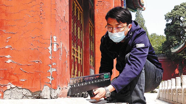 <p>Zhang Tao tests a wooden pillar with a micro-drilling impedance analyser </p>