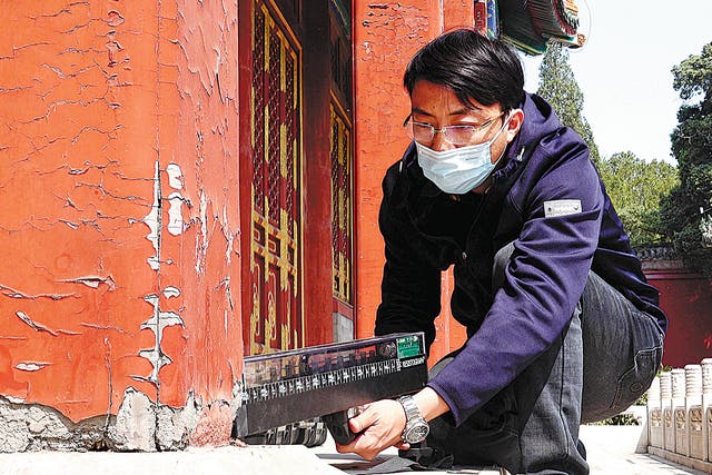<p>Zhang Tao tests a wooden pillar with a micro-drilling impedance analyser </p>