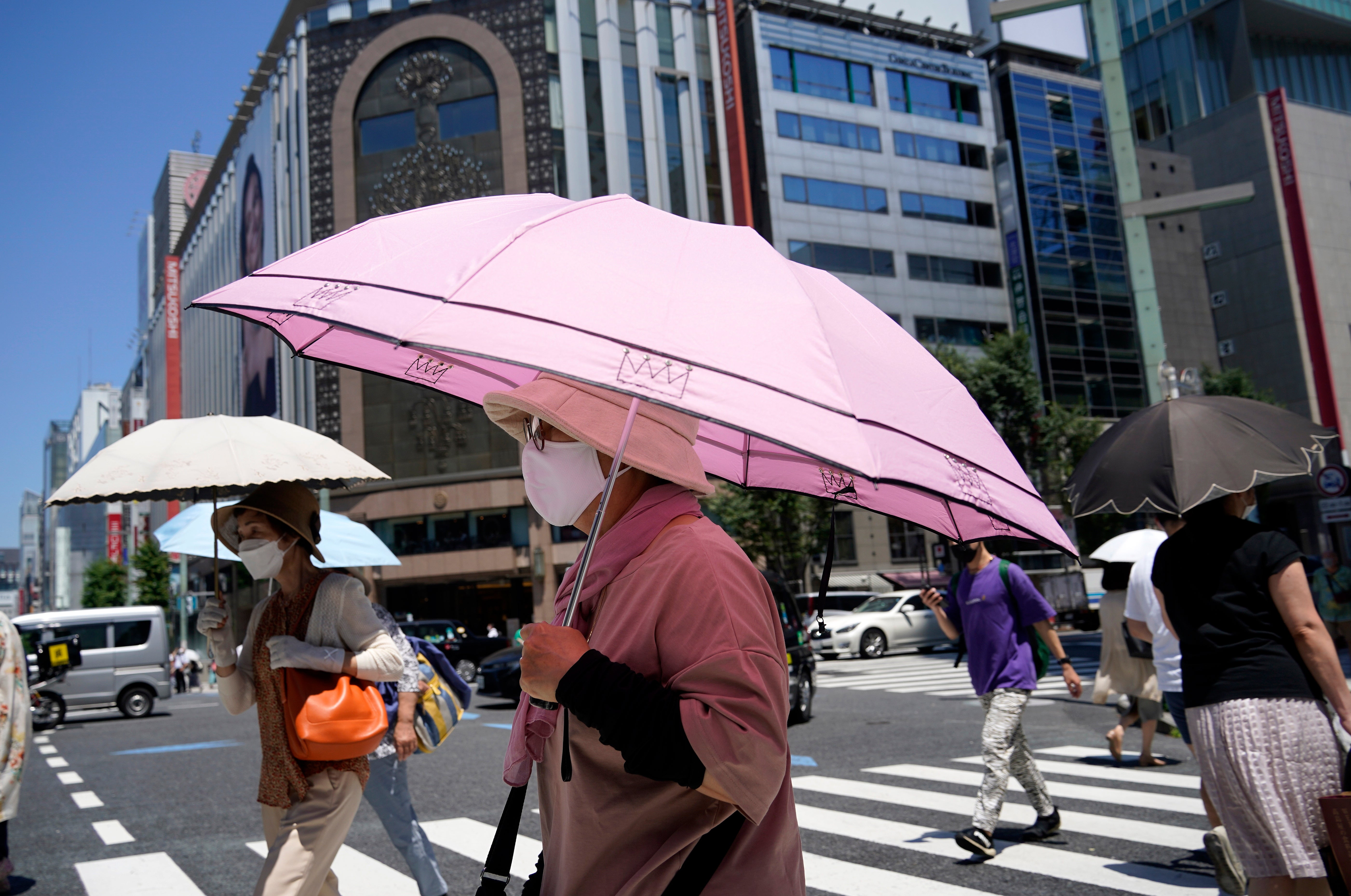 People shielding themselves from the heat in Tokyo during a heatwave in June