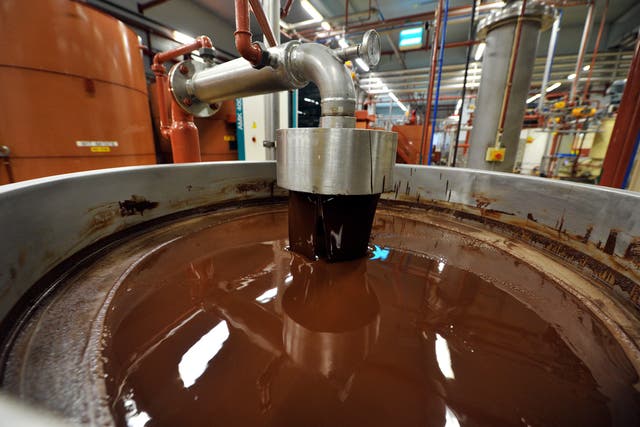 <p>Rescuers cut a hole into the bottom of the partly-full chocolate tank  </p>