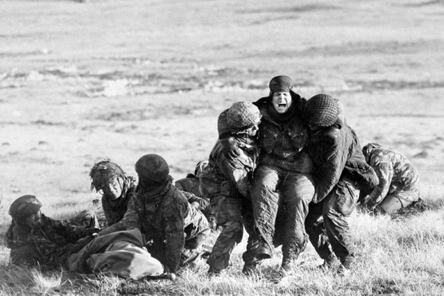 <p>British paratroopers carrying out emergency medical treatment on wounded comrades whilst under fire on Mount Longdon during the Falklands campaign in 1982 PA Photo</p>