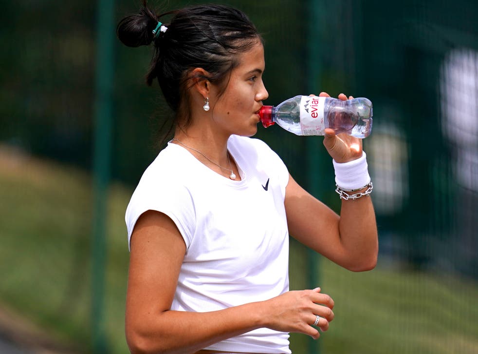 <p>Emma Raducanu takes a drinks break during a practice session ahead of the 2022 Wimbledon Championship</p>