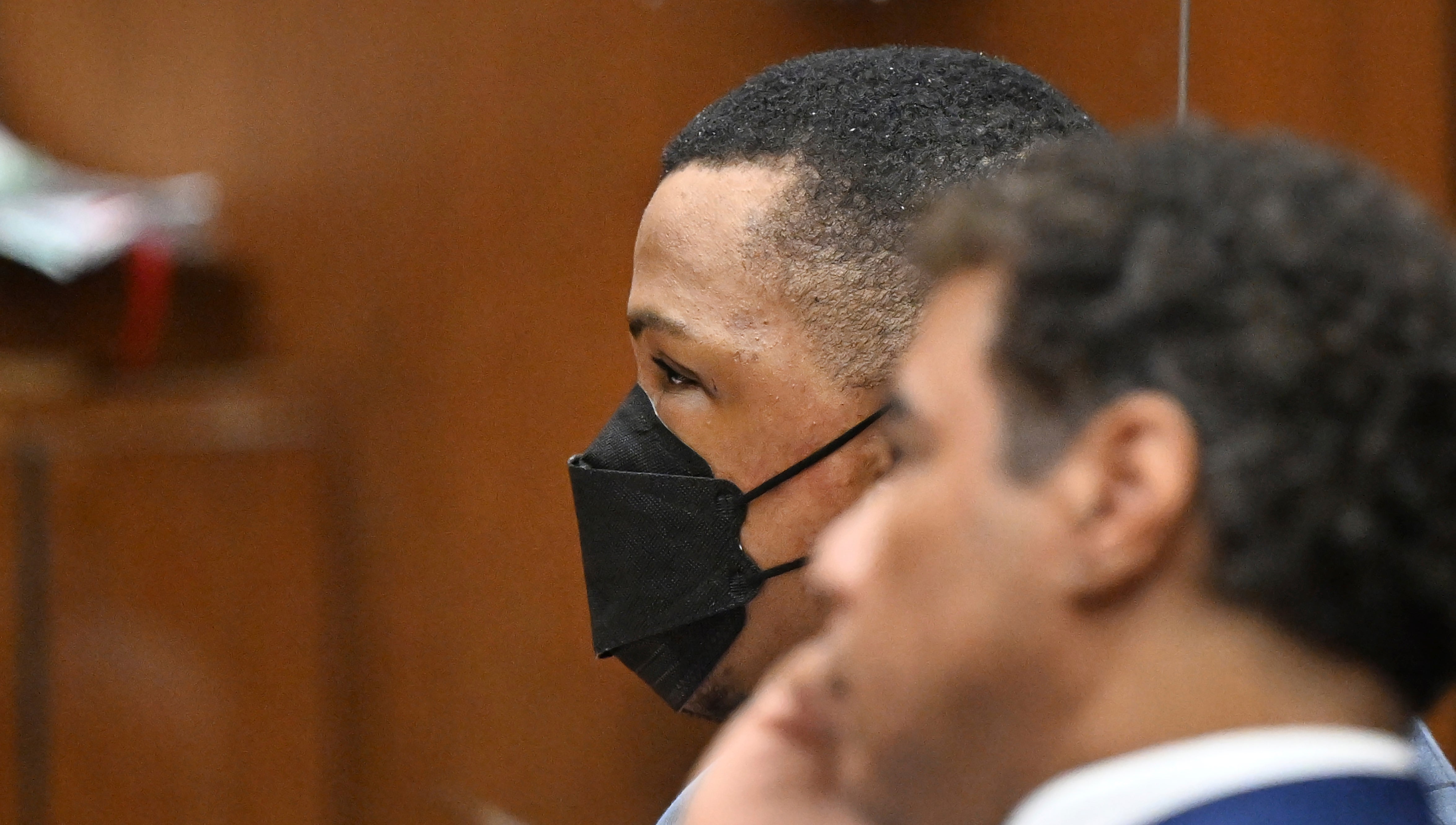 Eric Holder, left looks on with his attorney during closing arguments at his trial for the murder of Nipsey Hussle