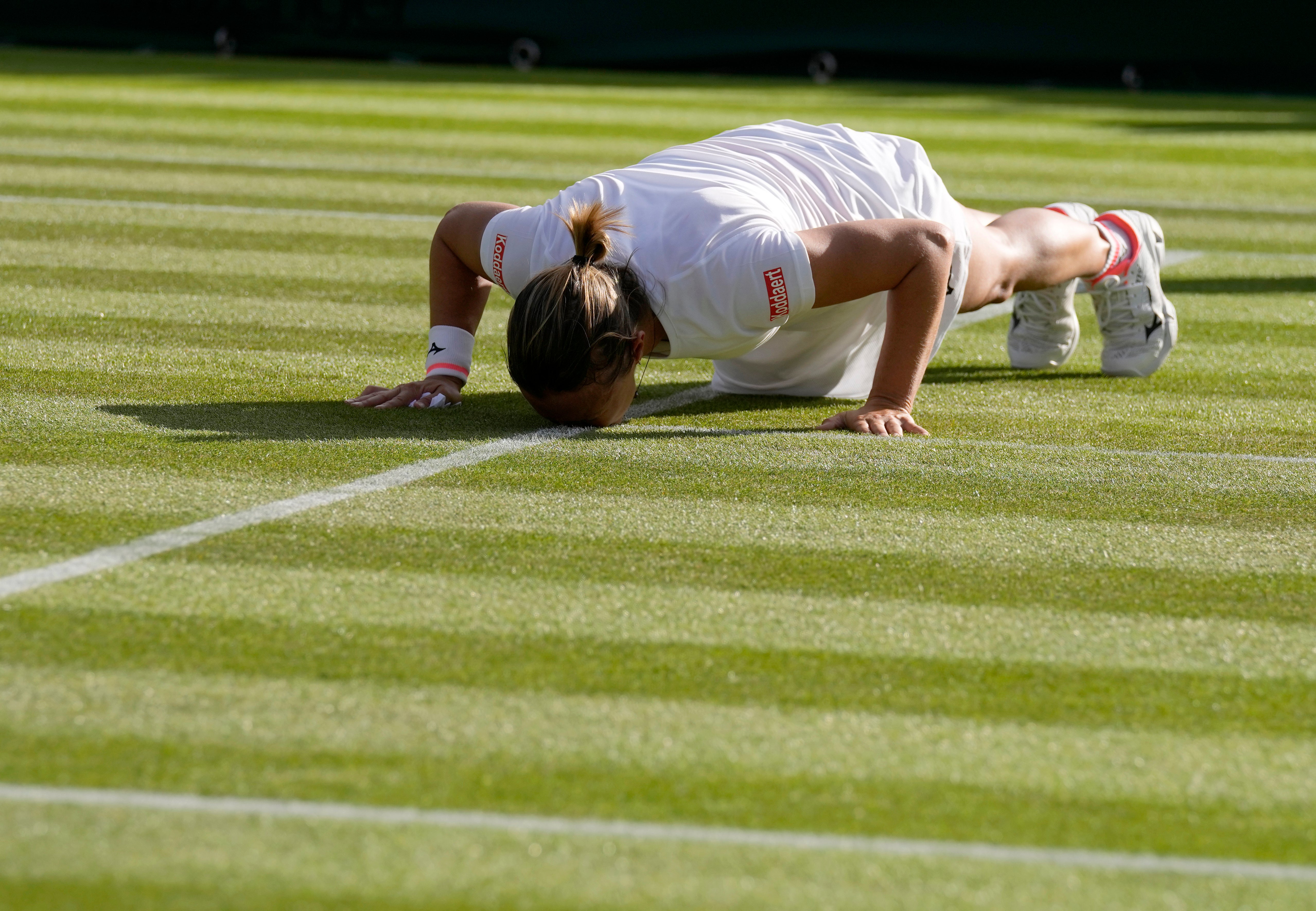 Kirsten Flipkens kisses the grass on Court Two at the end of her second round match with Simona Halep, which marked the end of her professional singles career (Alastair Grant/AP/PA)