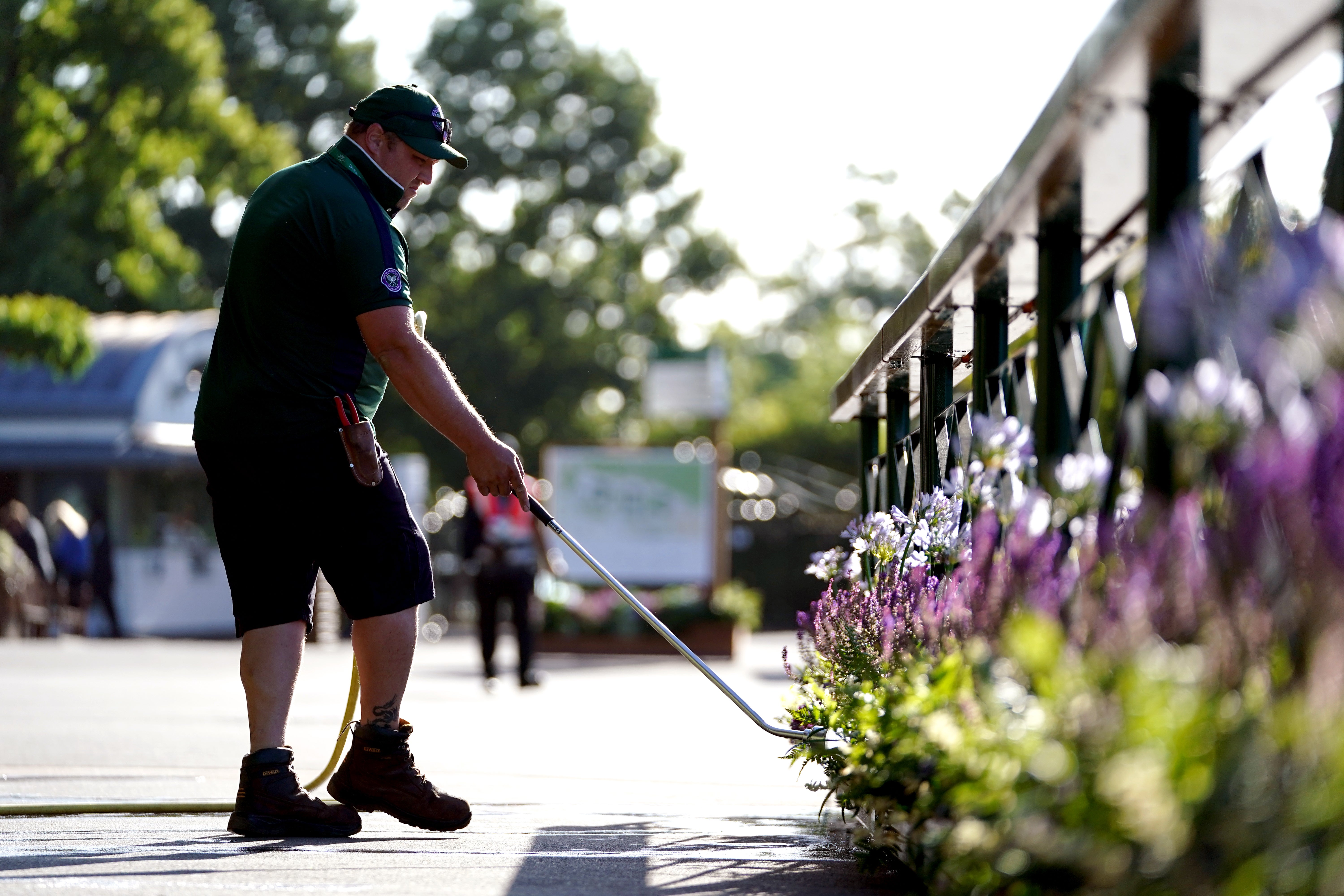 Ground staff water flowers outside of Centre Court ahead of day one of the 2022 Wimbledon Championships (Zac Goodwin/PA)
