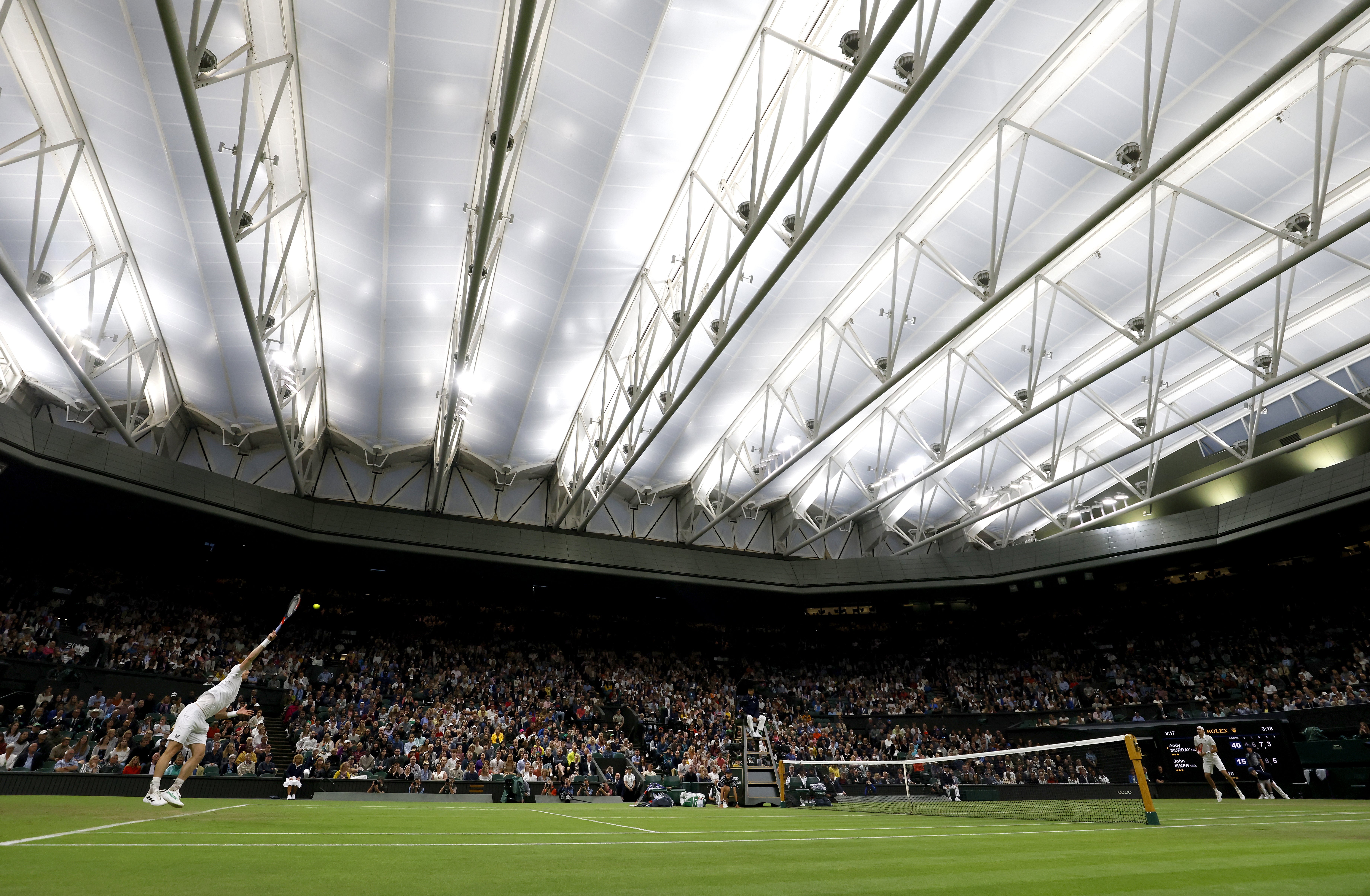 Great Britain’s Sir Andy Murray in action against USA’s John Isner under the LED Centre Court lights (Steven Paston/PA)