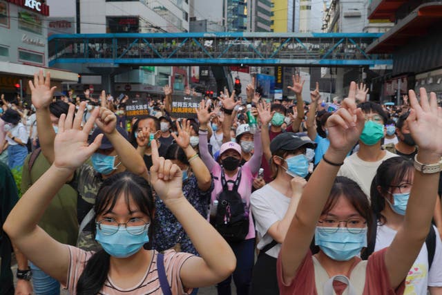 <p>File. Protesters against the national security law march and gesture with five fingers, signifying the "Five demands - not one less" on the anniversary of Hong Kong's handover to China from Britain in Hong Kong on July 1, 2020</p>