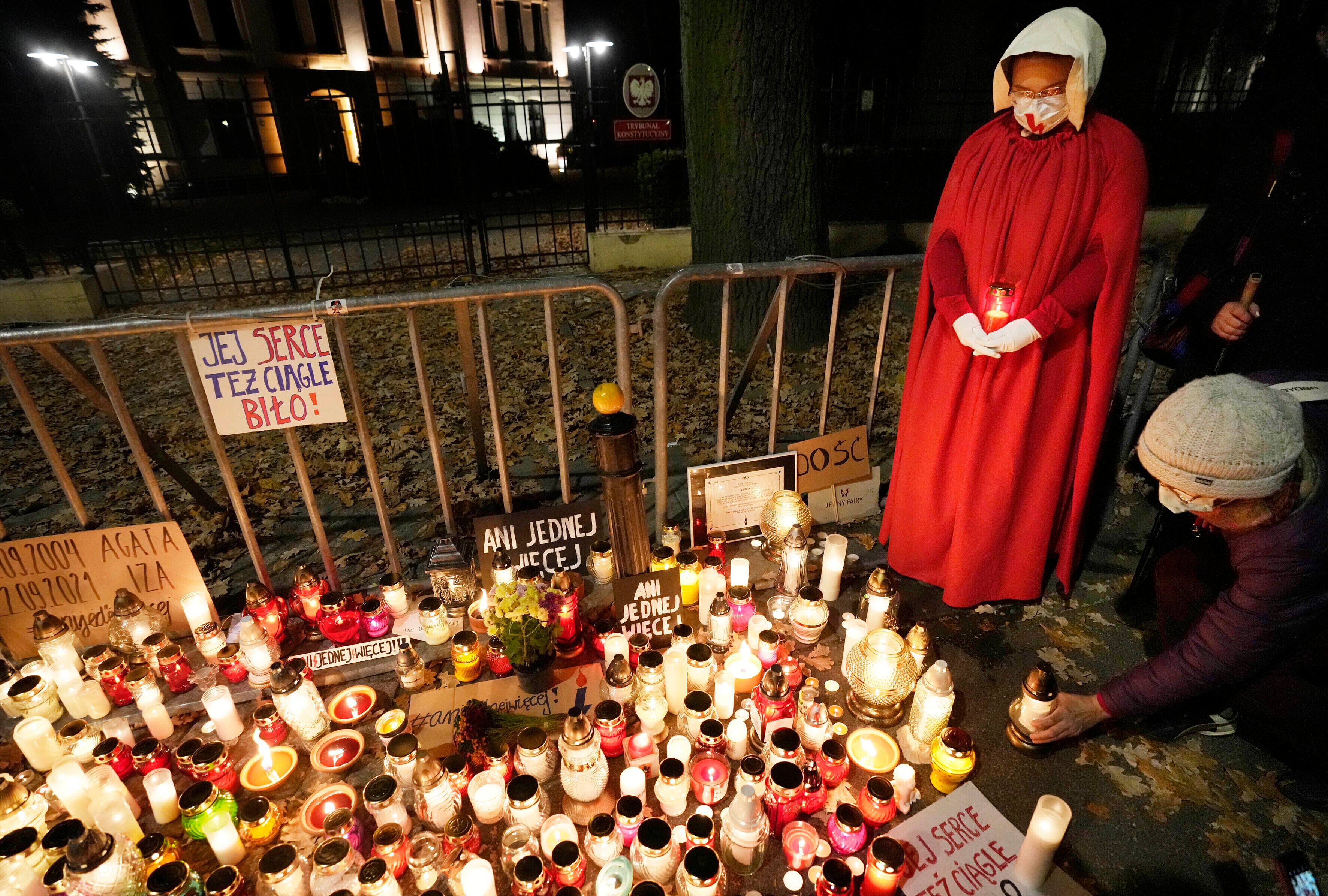 People place candles in tribute to a woman who died in the 22nd week of pregnancy, in Warsaw, Poland, last November