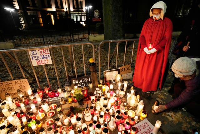<p>People place candles in tribute to a woman who died in the 22nd week of pregnancy, in Warsaw, Poland, last November </p>