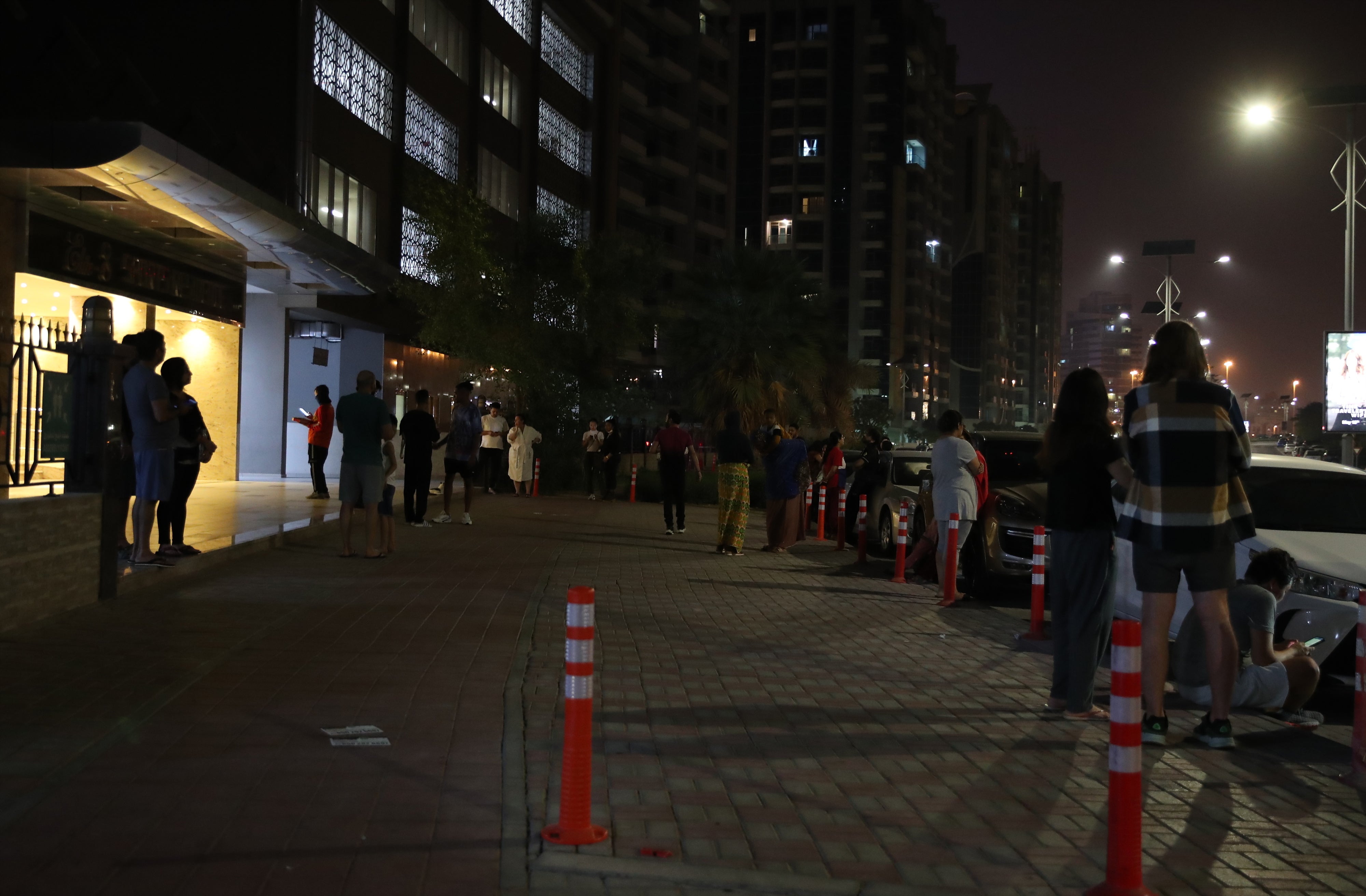 People gather in front of their residential building in the Gulf emirate of Dubai, United Arab Emirates, in the early hours of 2 July 2022. A recorded earthquake of magnitude 6.3 has hit southern Iran with tremors felt in Dubai