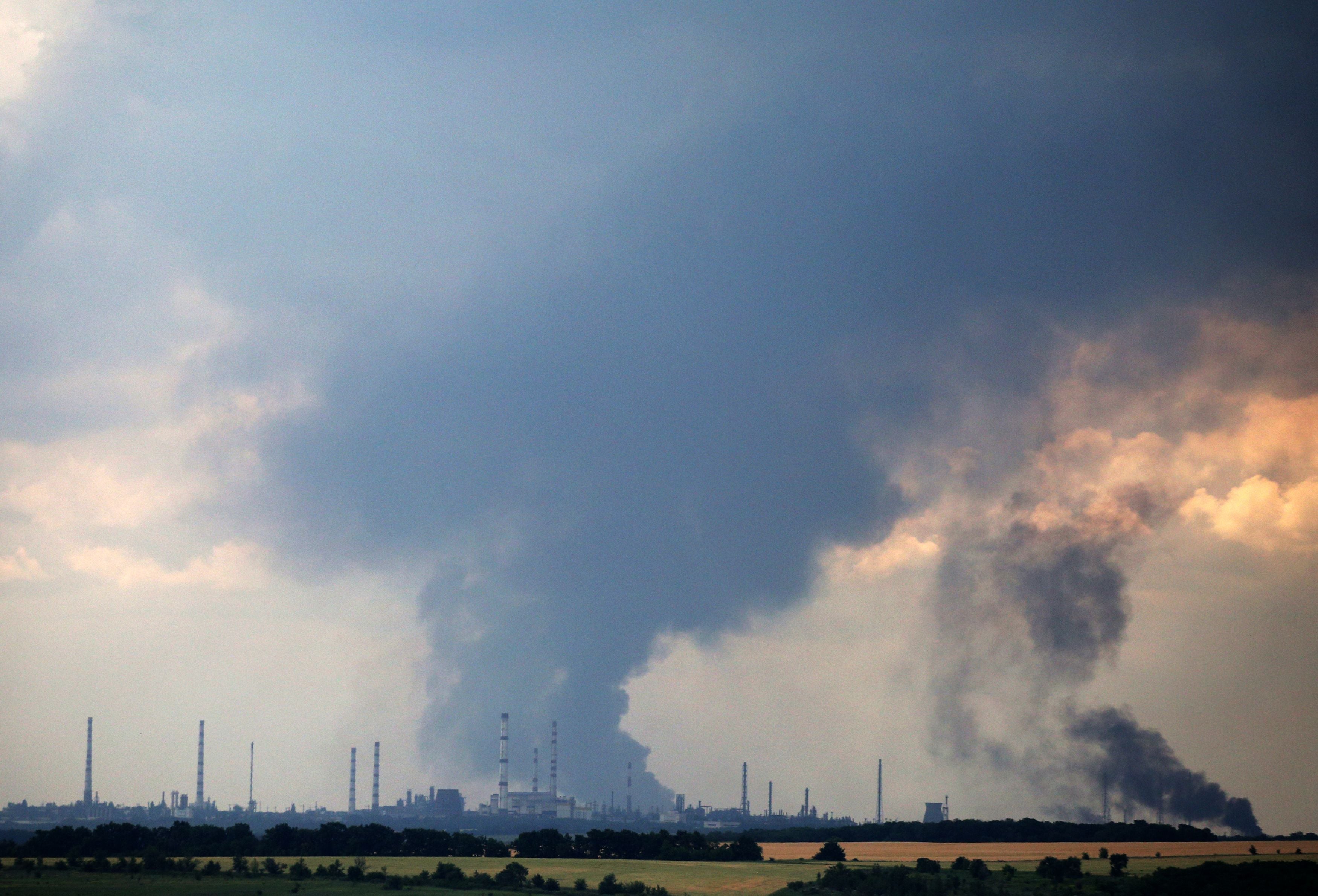 Smoke billows over the oil refinery outside the town of Lysychansk