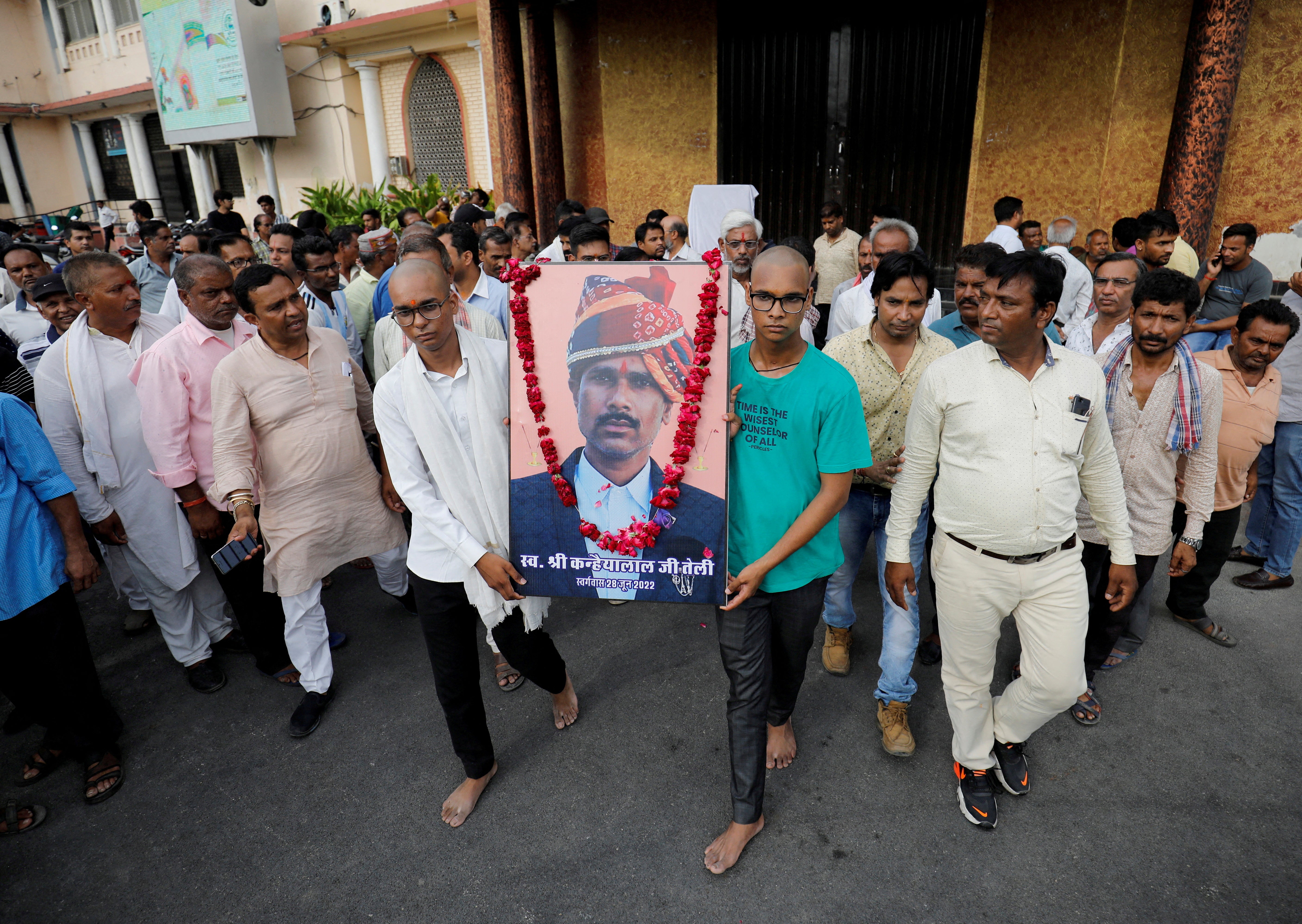 <p>Two sons of Kanhaiyalal Teli, a Hindu tailor, carry a portrait of their father after a prayer meeting in Udaipur</p>