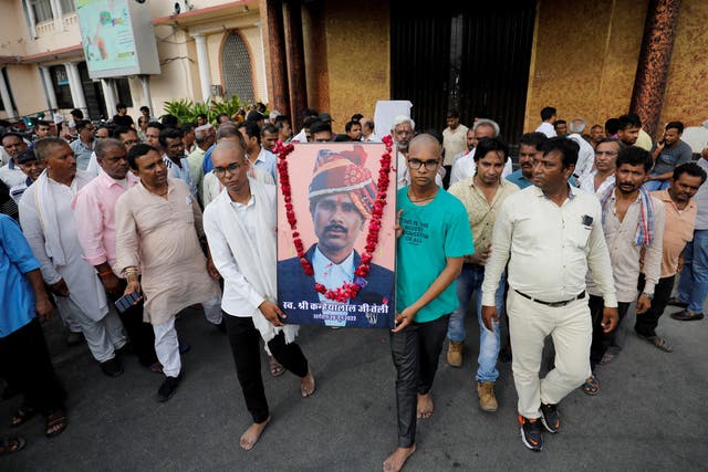 <p>Two sons of Kanhaiyalal Teli, a Hindu tailor, carry a portrait of their father after a prayer meeting in Udaipur</p>