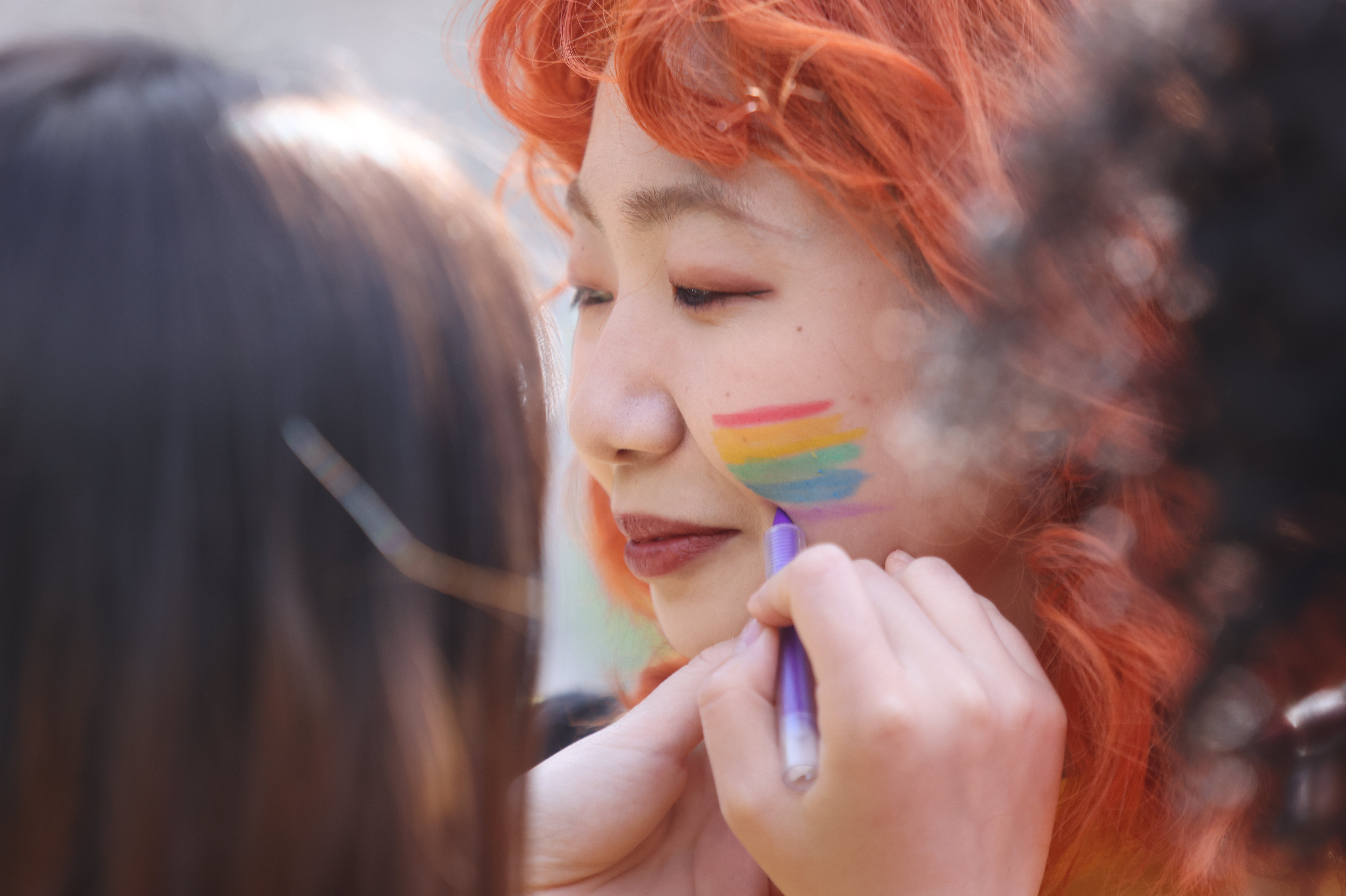 Pride volunteers paint each other’s faces (James Manning/PA)