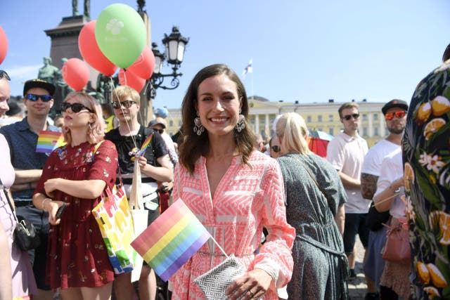 <p>Finnish Prime Minister Sanna Marin holds a rainbow flag as she takes part in the 2022 Helsinki Pride march</p>
