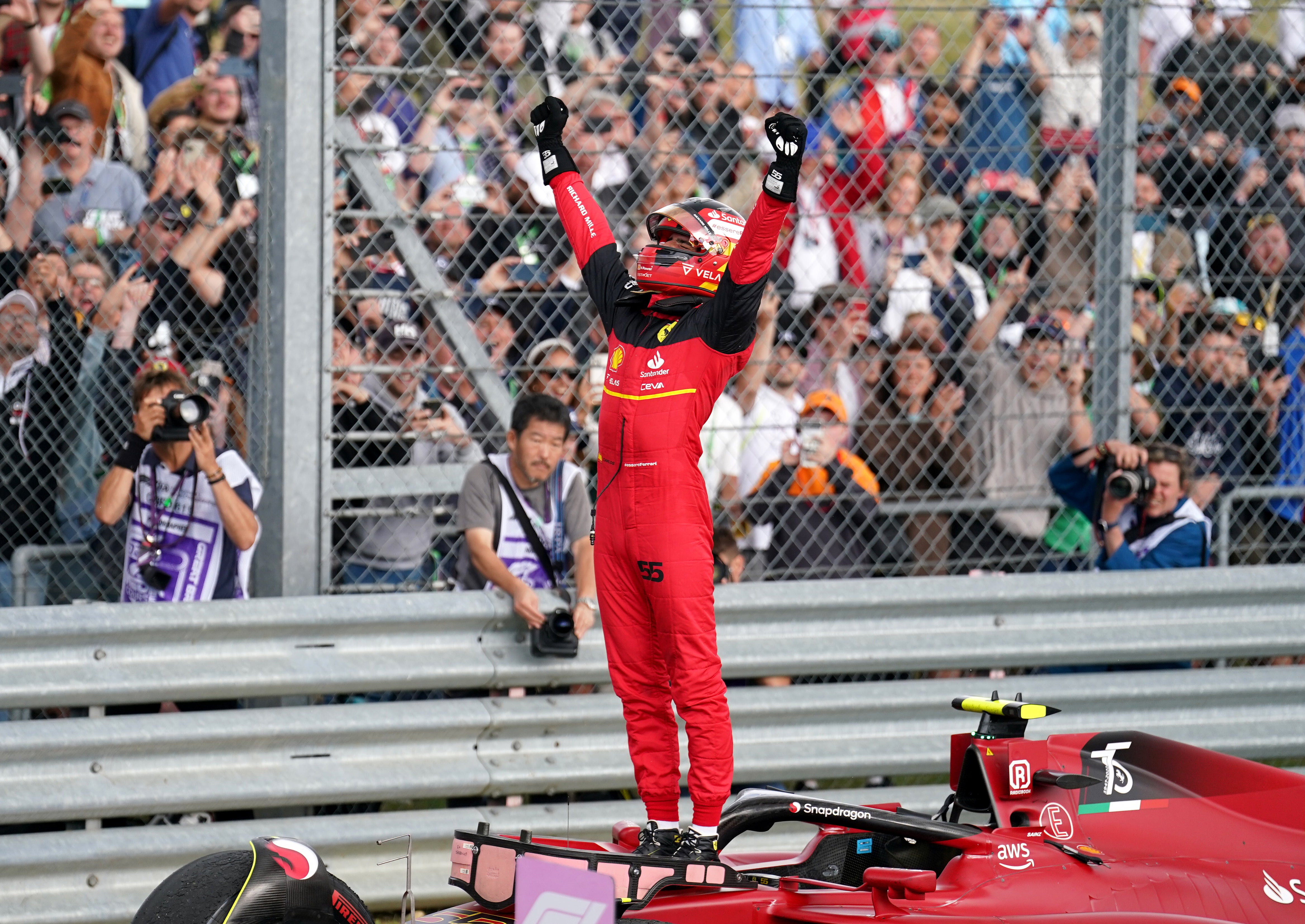 Carlos Sainz stands on top of his car in celebration (Tim Goode/PA)