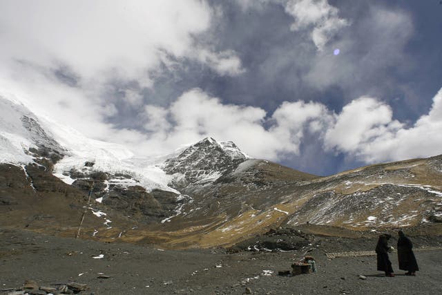 <p>Two Tibetan woman stand at the foot of the 7,191m Nojing Kangtsang glacier</p>