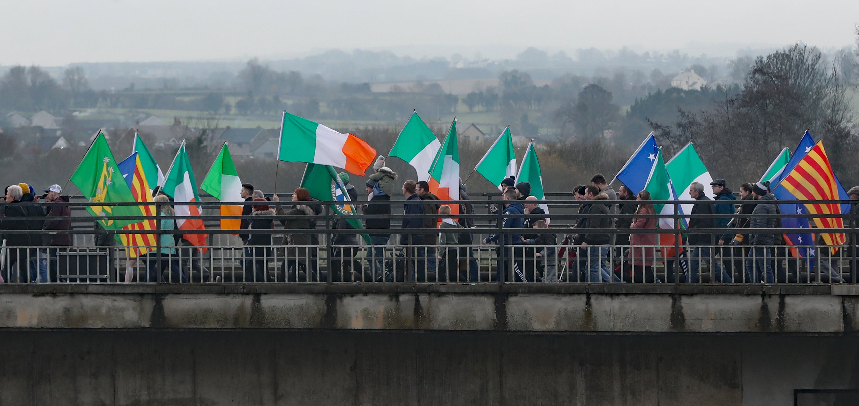 People take part in an Irish unity march as they cross the Lifford Bridge (Niall Carson/PA)