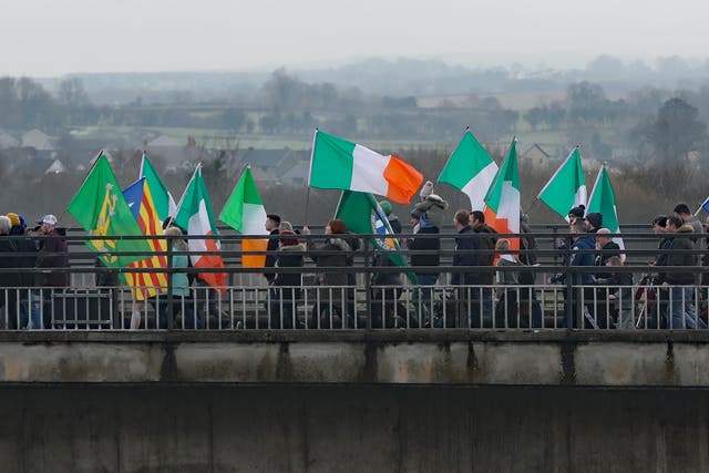 People take part in an Irish unity march as they cross the Lifford Bridge (Niall Carson/PA)