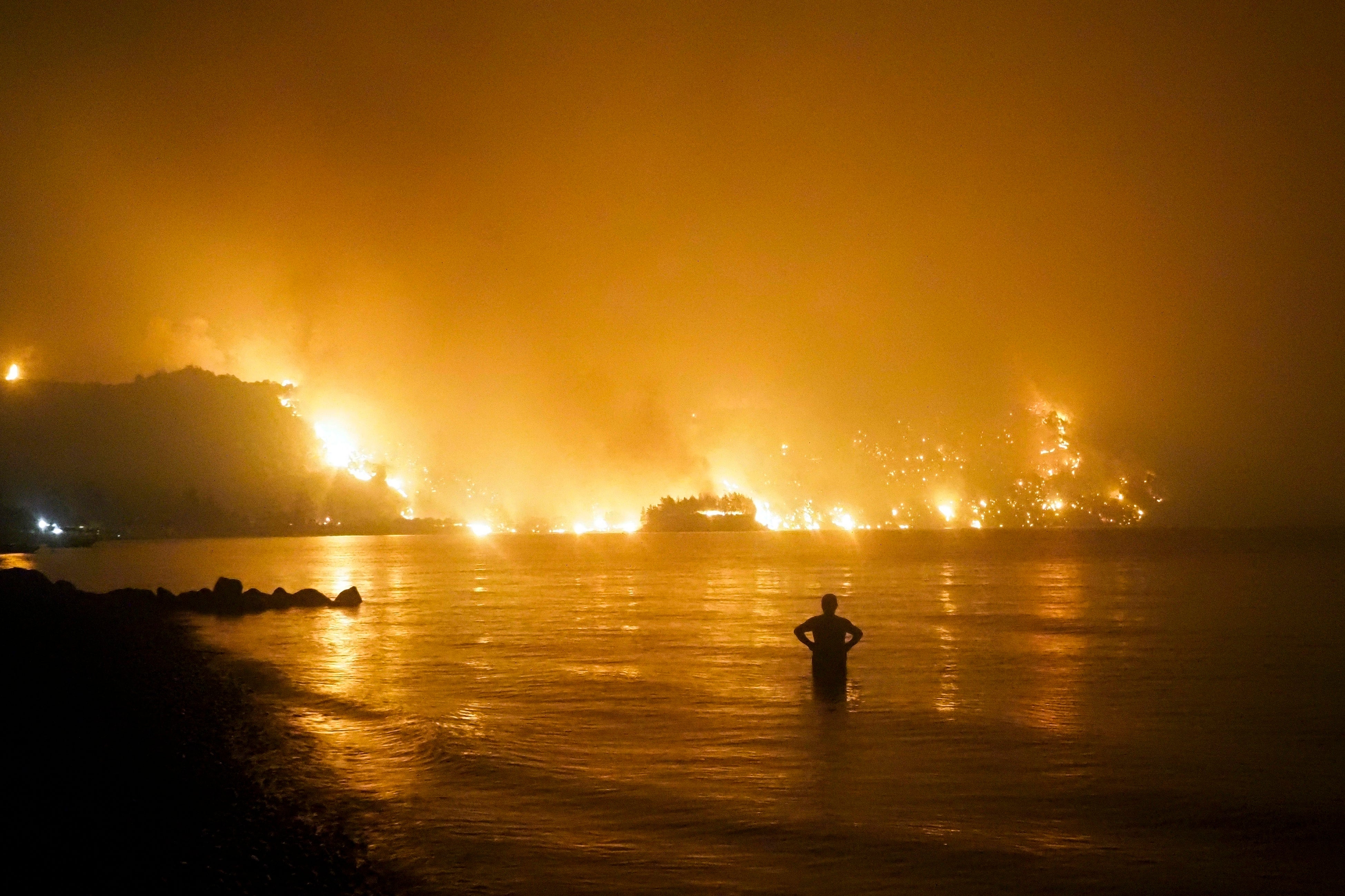 A man watches as a wildfire approaches Kochyli beach near the village of Limni, on the Evia island, Greece, in August last year