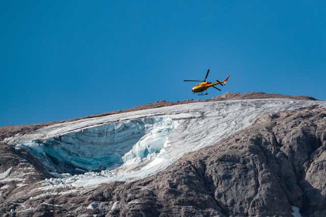 <p>A rescue helicopter flies on July 4, 2022 over the glacier that collapsed the day before on the mountain of Marmolada, the highest in the Dolomites</p>